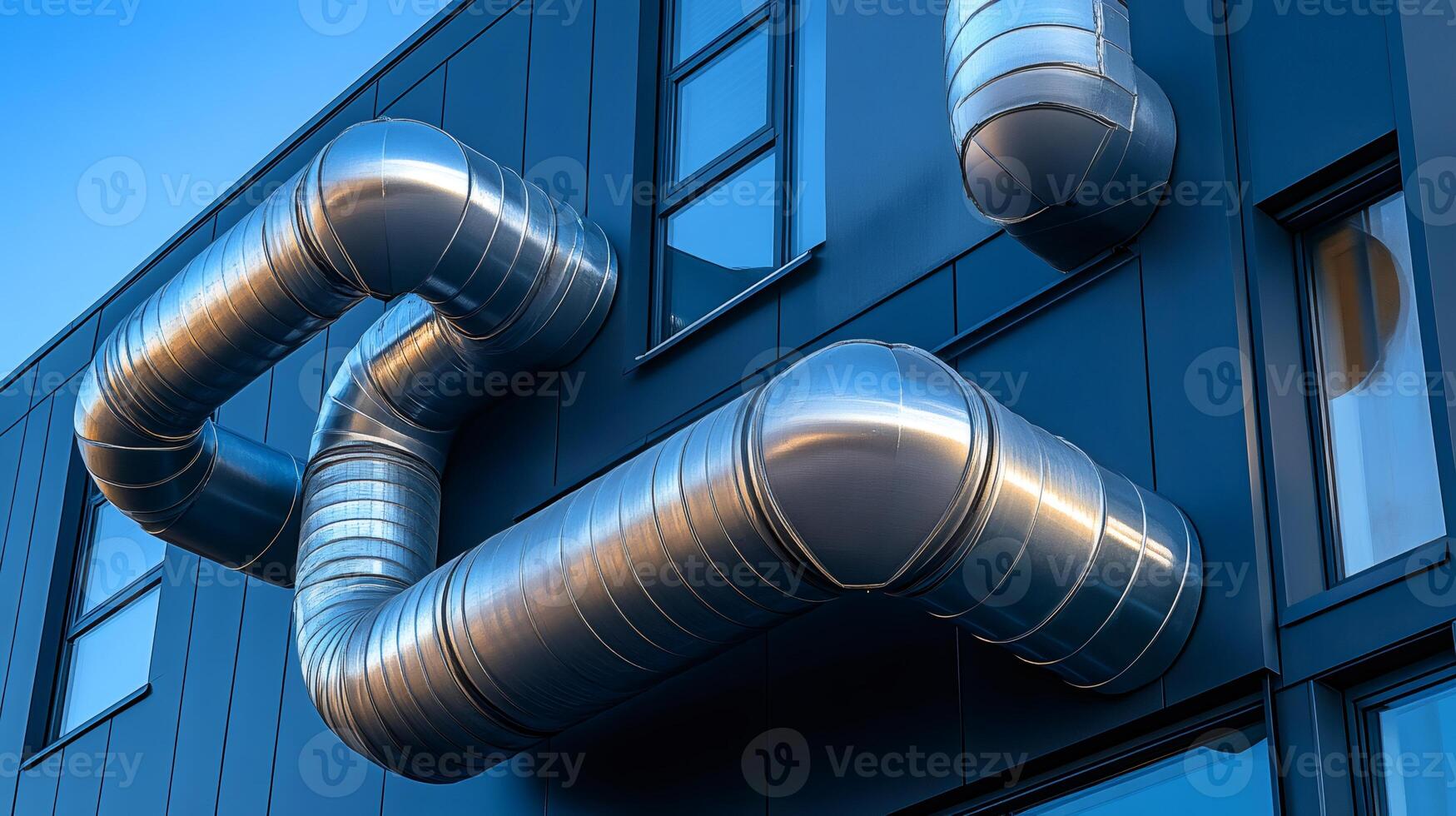 Ventilation system pipes running along modern building exterior photo