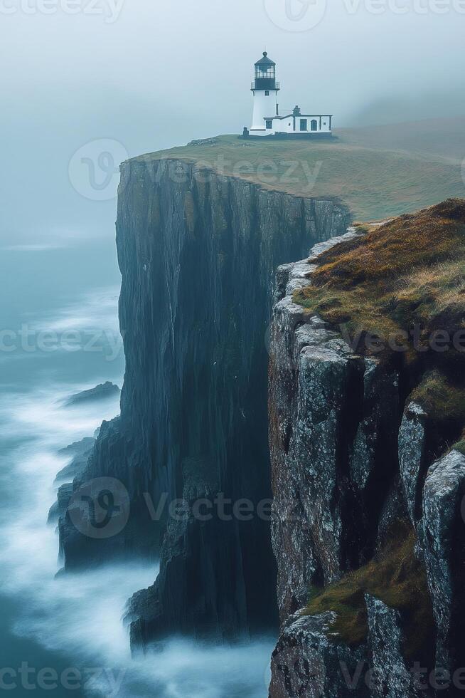 Neist point lighthouse standing on misty cliffs in scotland photo