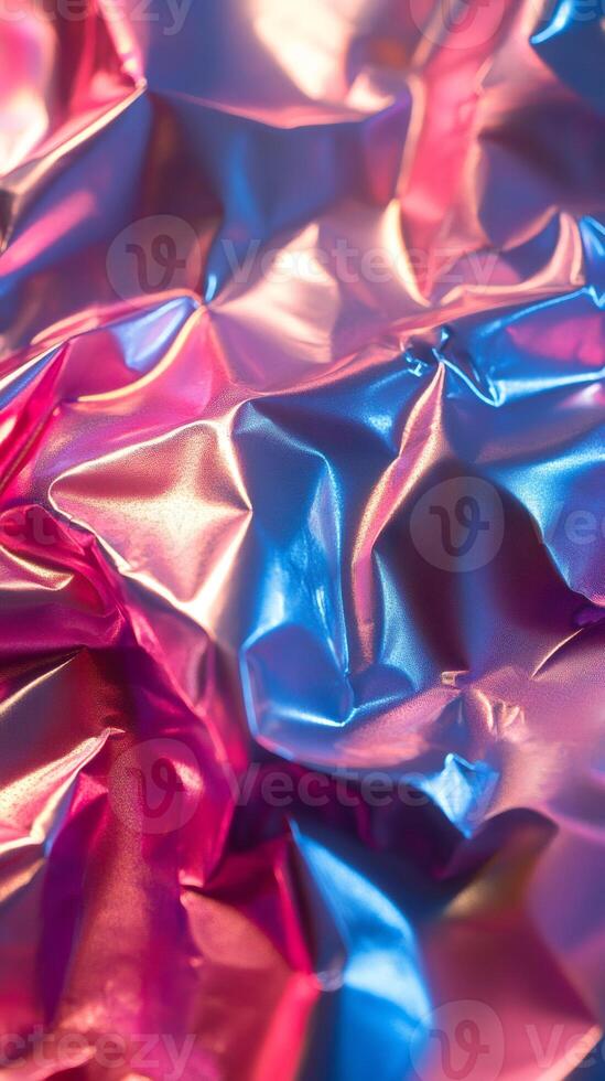 Crumpled holographic foil reflecting pink and blue light photo
