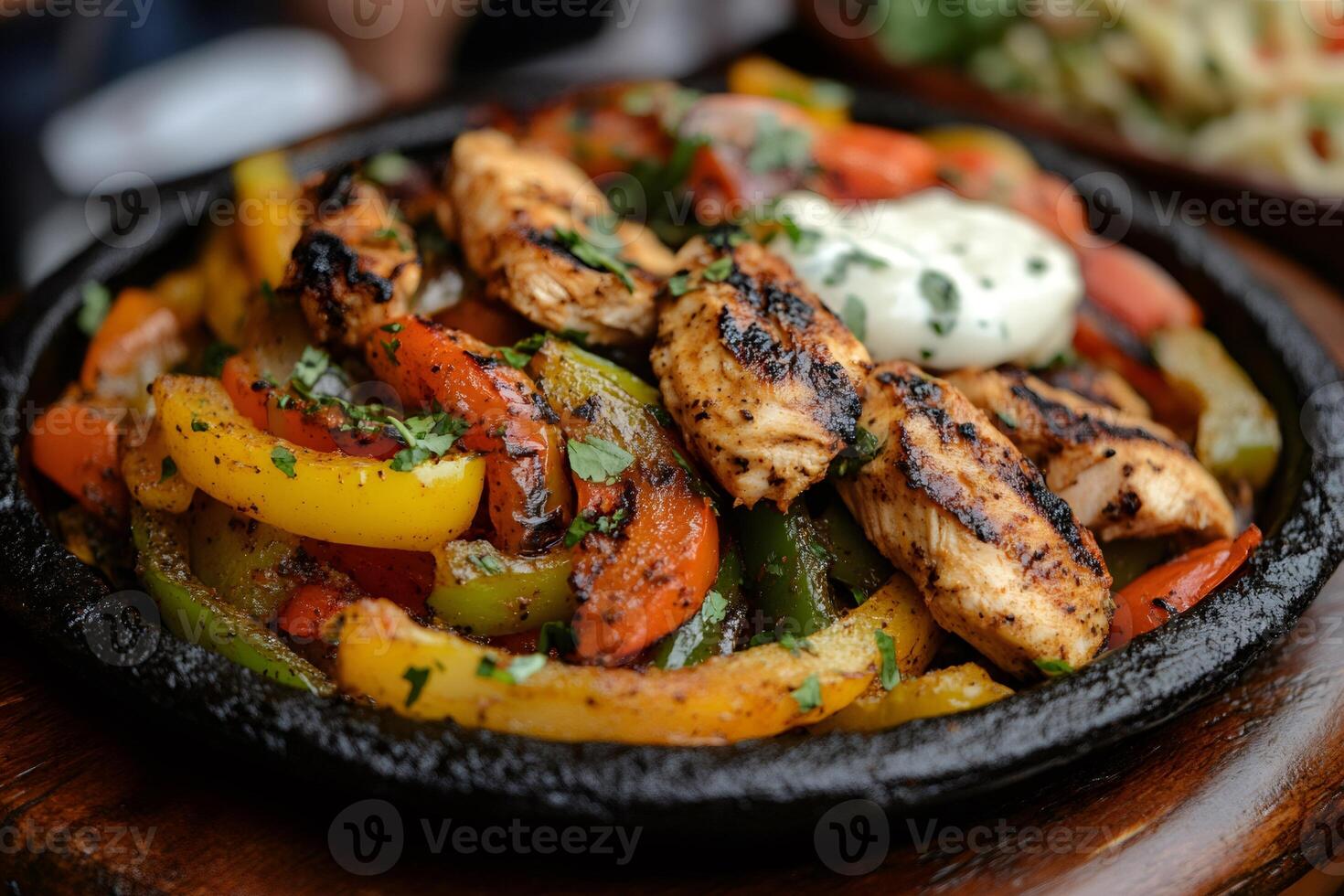Sizzling chicken fajitas with colorful bell peppers and a dollop of sour cream photo