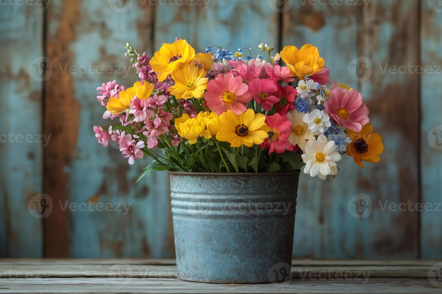 Colorful bouquet of flowers sitting in metal pot on rustic wooden table photo