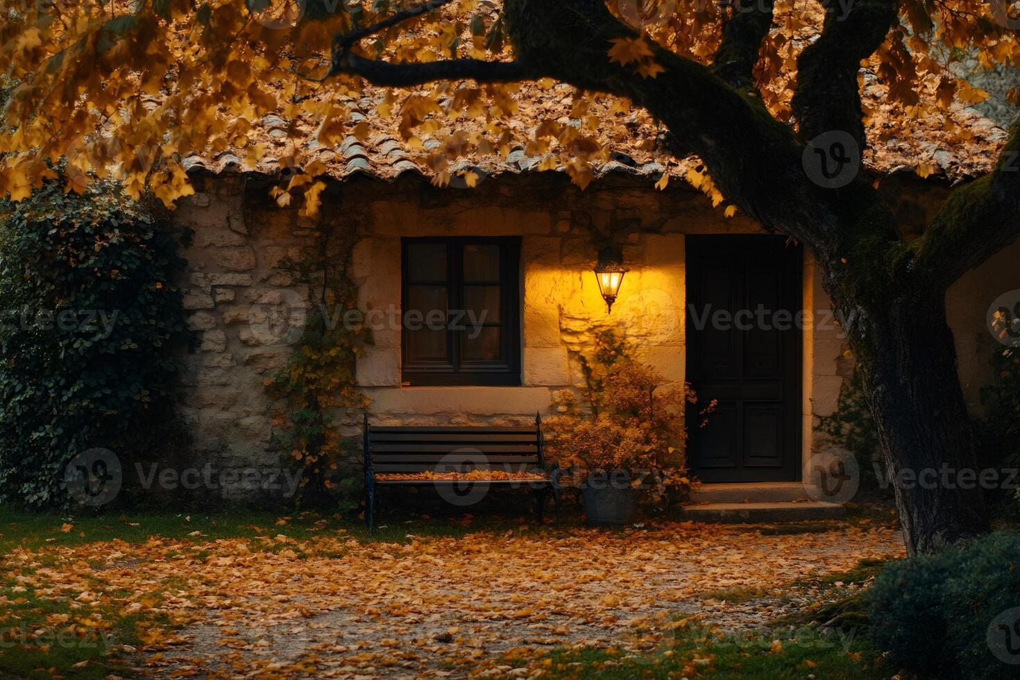 Cozy stone cottage illuminated by warm light on an autumn evening photo