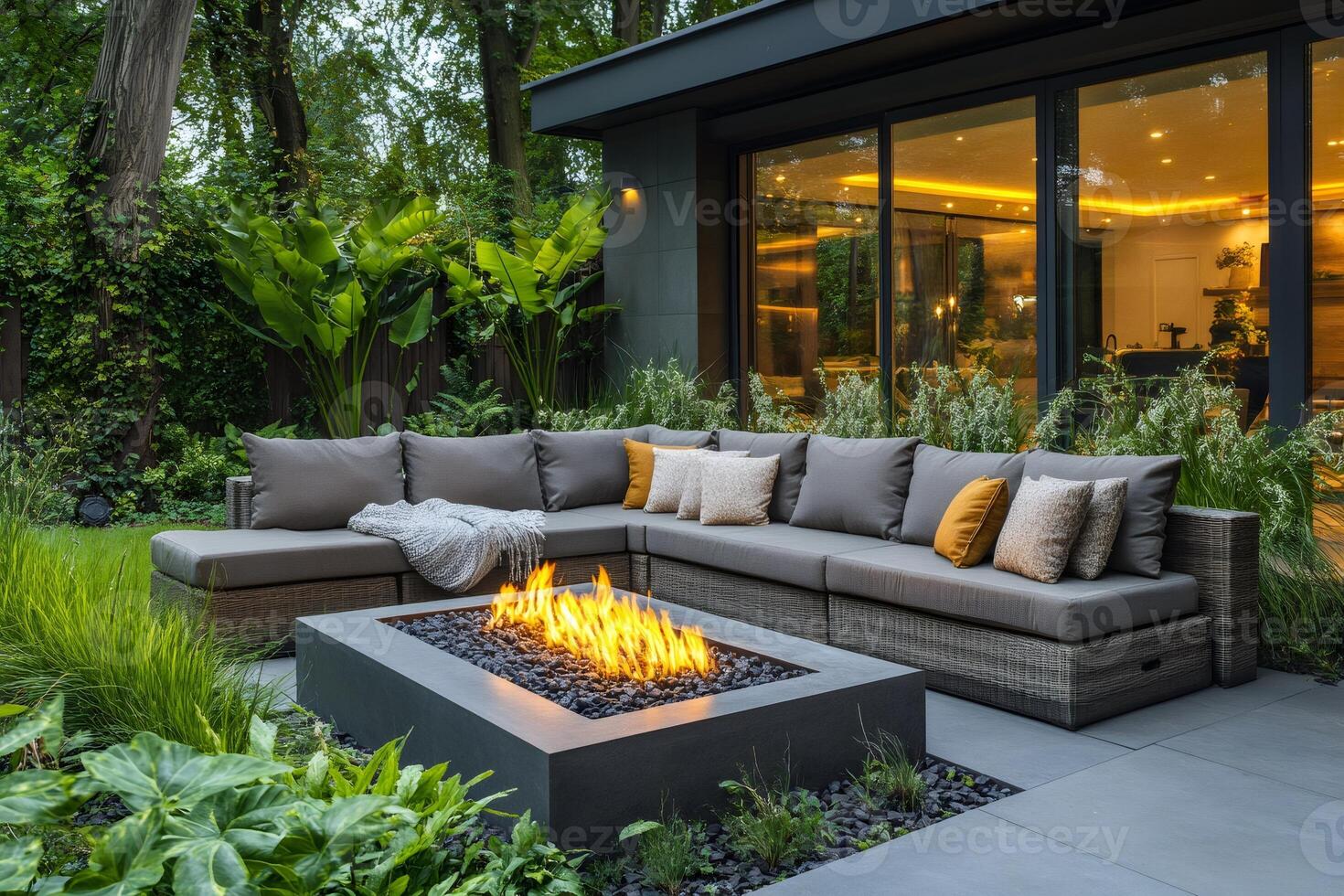 Modern backyard patio with fire pit and comfortable sectional sofa during evening photo