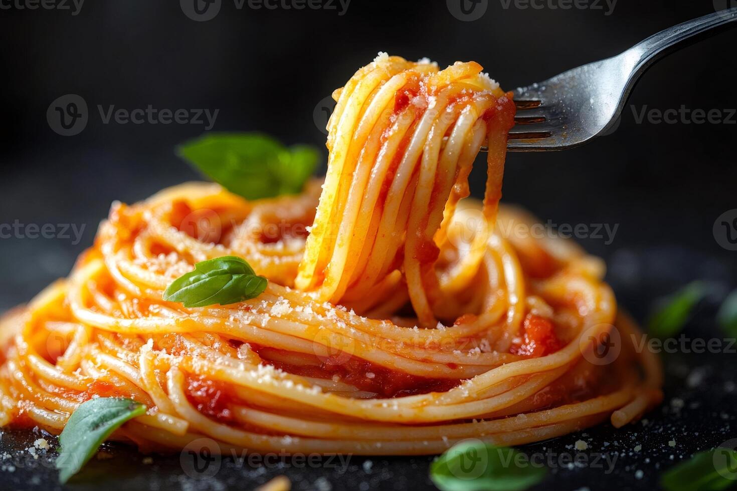 Fork lifting tasty long spaghetti with marinara sauce and basil photo
