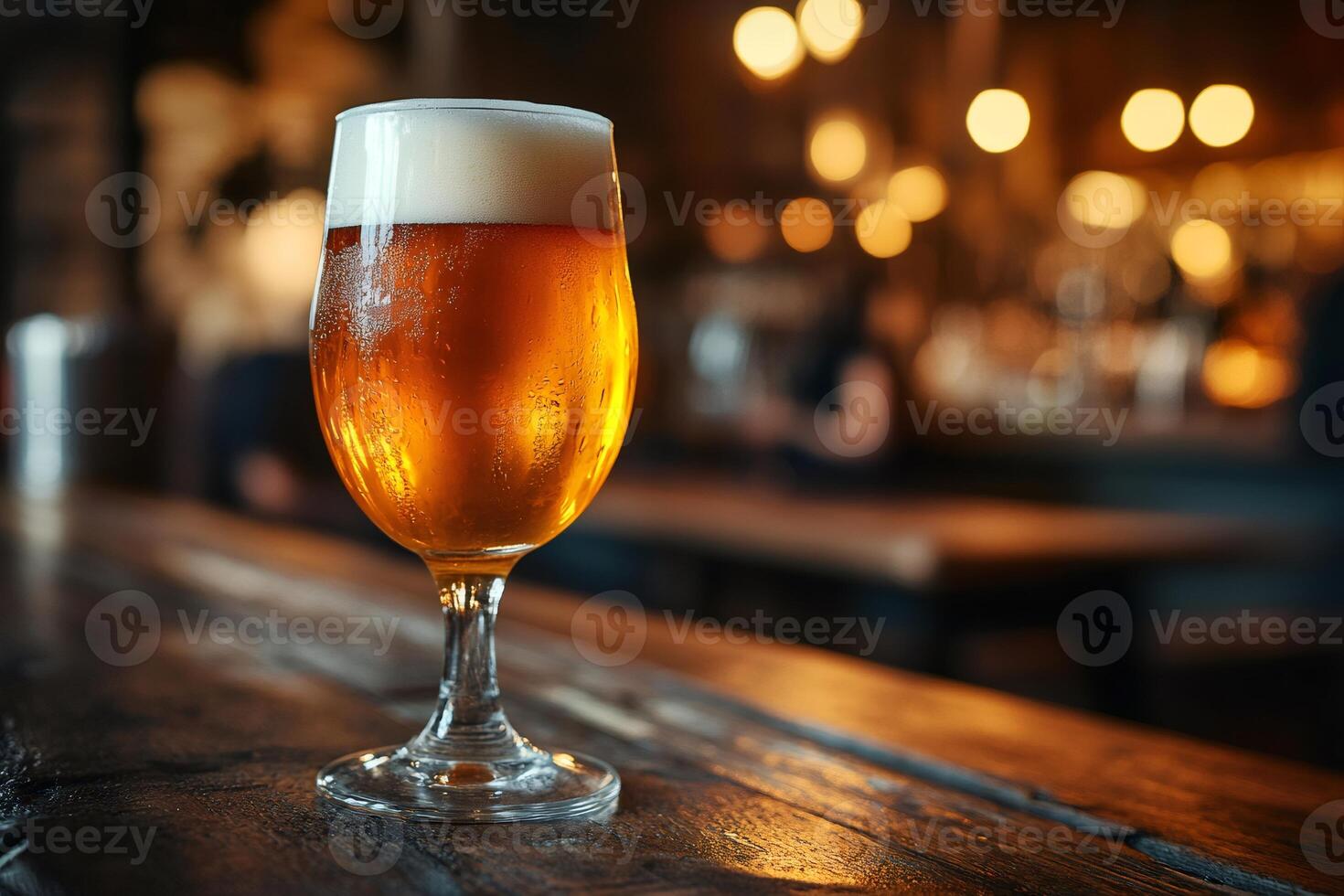 Cold glass of beer resting on wooden table in pub photo