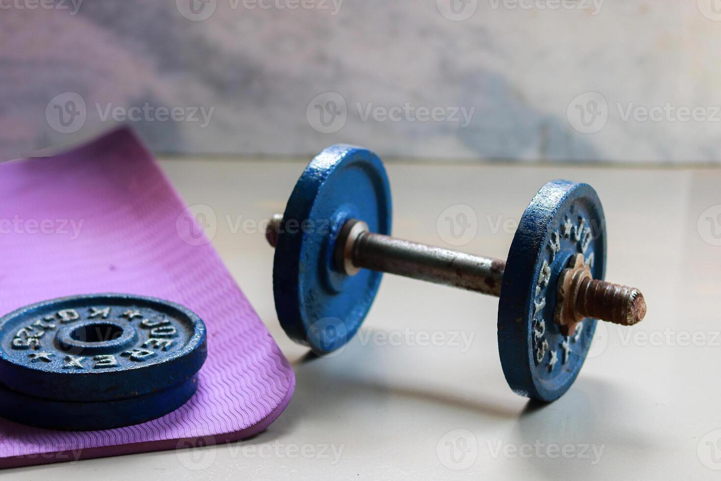 Dumbbell and yoga mat on the floor in the gym. photo