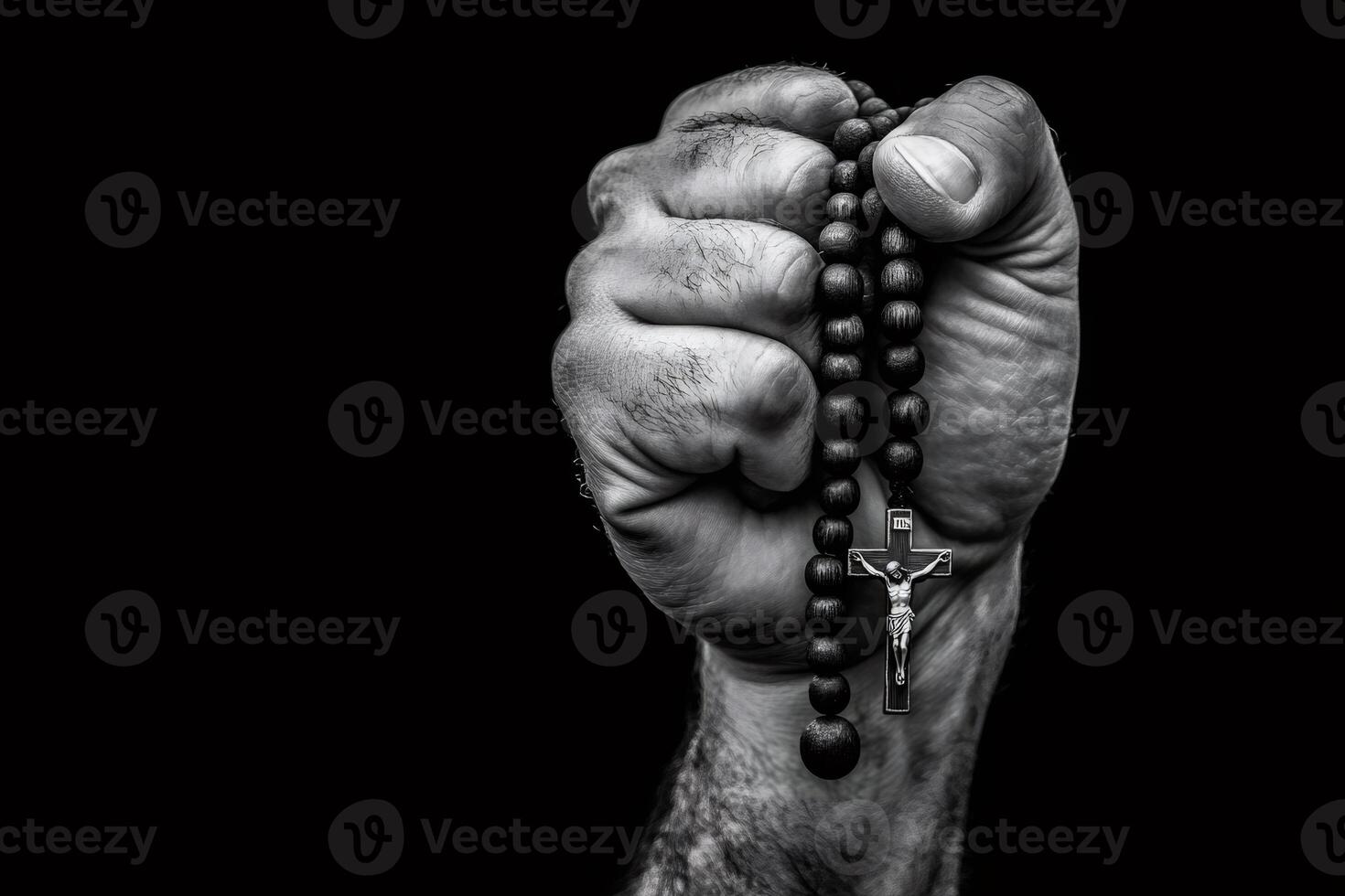 Hand holding rosary beads and crucifix on dark background photo