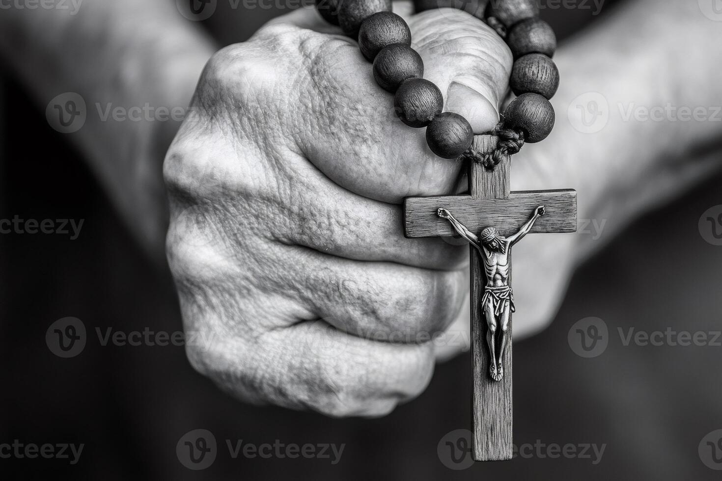 Senior man praying with rosary beads and crucifix in black and white photo