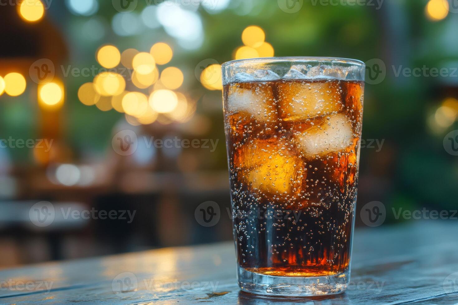 Refreshing sparkling drink with ice cubes on a table in outdoor cafe setting photo