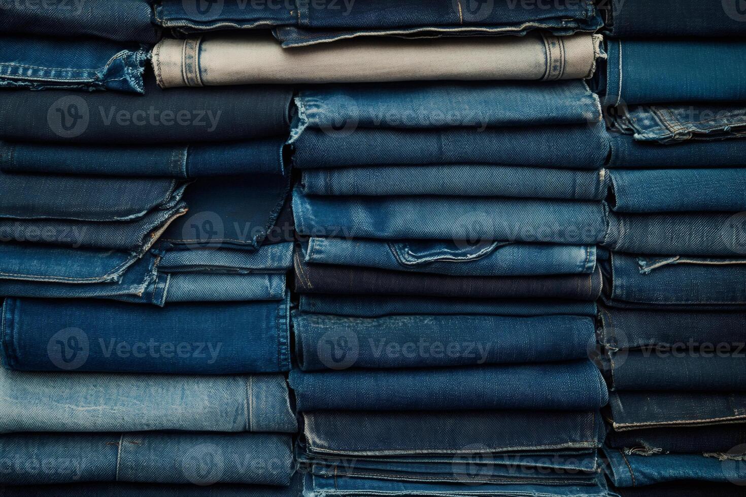 Stack of folded jeans showing various shades of blue denim photo