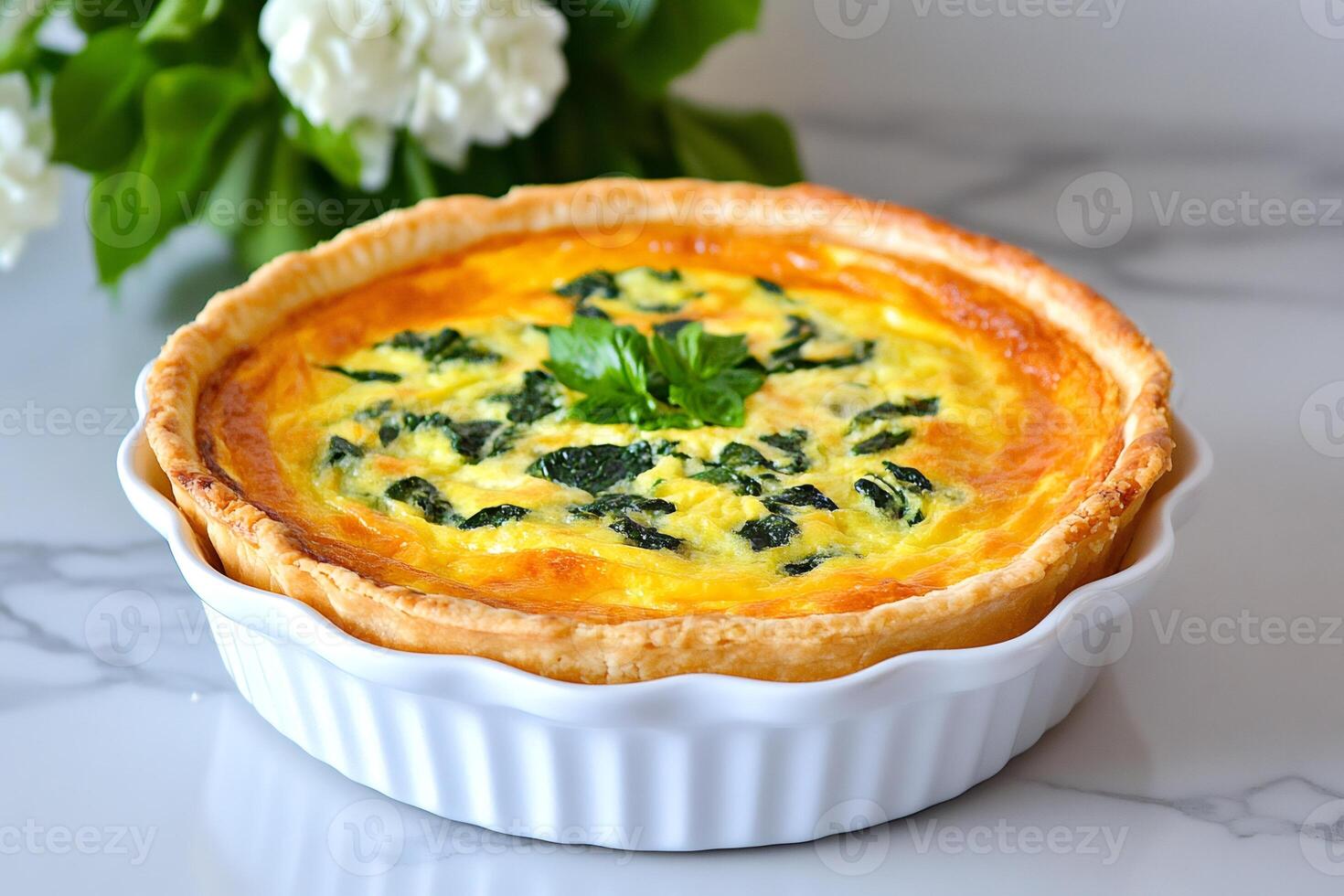 Delicious spinach quiche sitting in a white ceramic dish on marble table photo