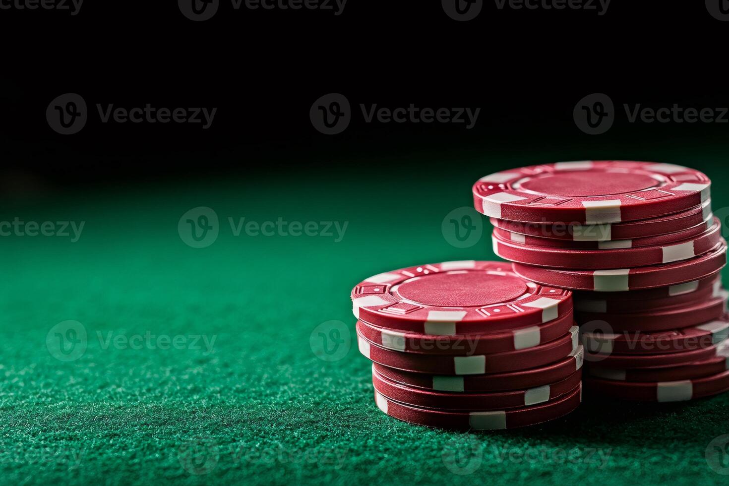 Red poker chips stacked on green felt table illuminating gambling theme photo