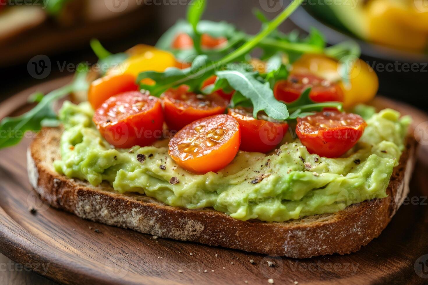 Toasted whole wheat bread with mashed avocado, tomatoes and arugula creating a healthy snack photo