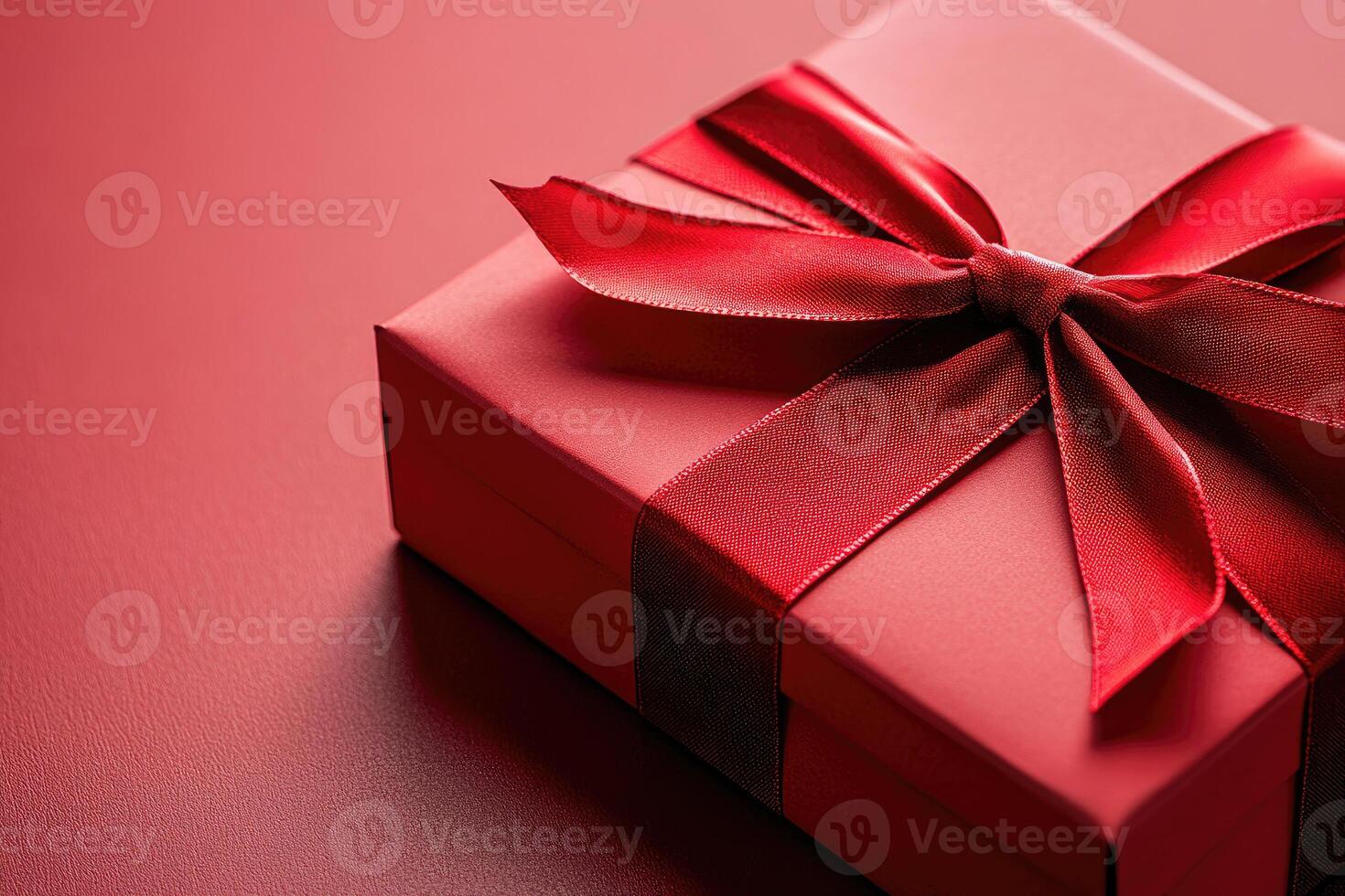 Elegant red gift box wrapped with beautiful bow on matching background photo