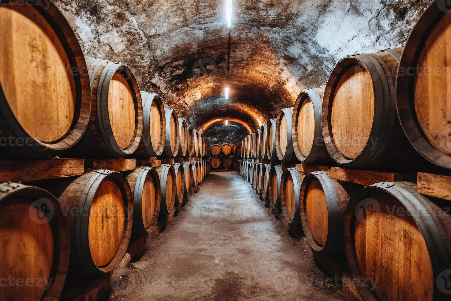 Wine cellar with wooden barrels aging in rows, creating a long corridor in a winery photo