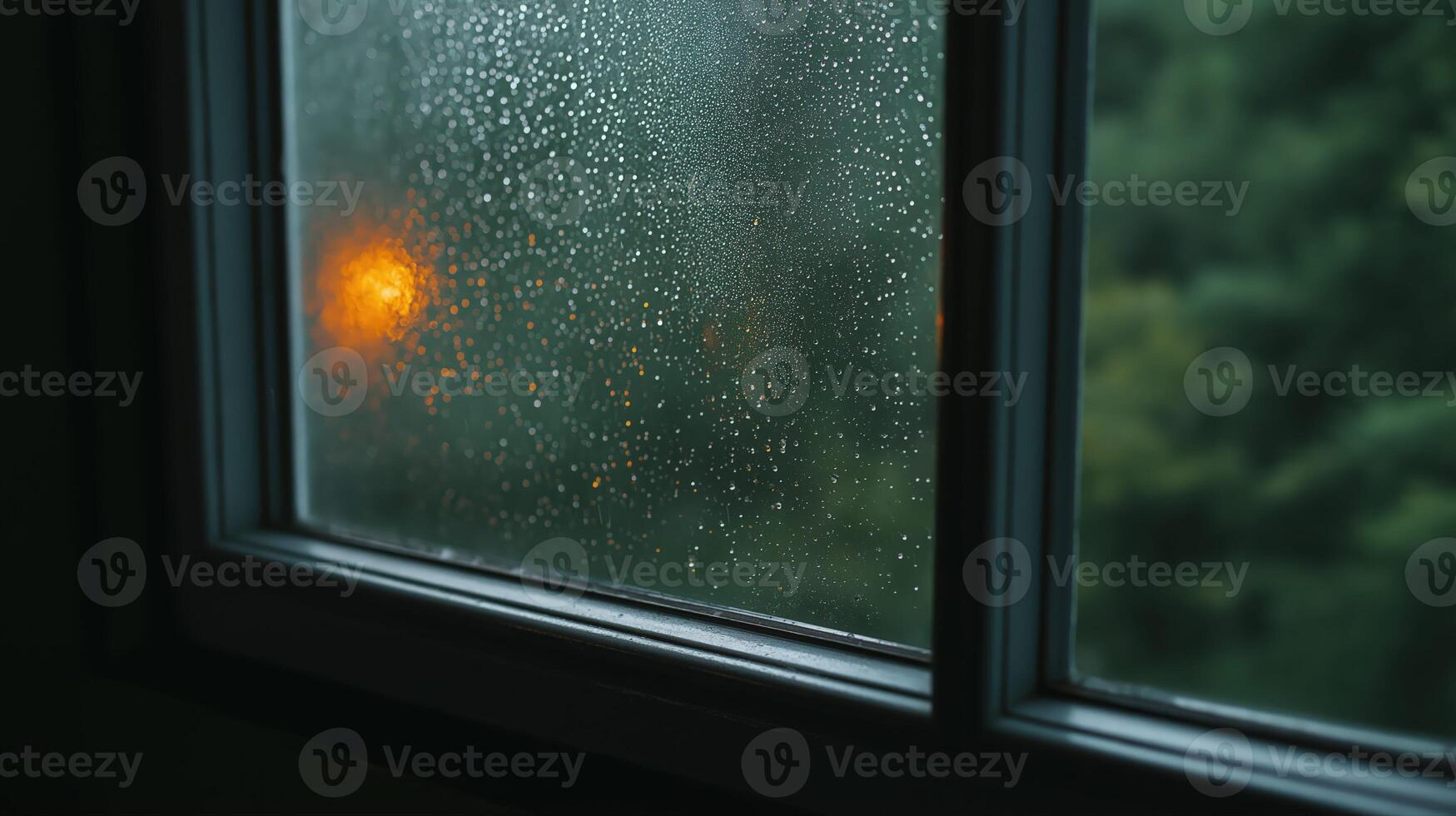Rainy Day Window View Rain Droplets on Glass, Orange Light, Blurred Green Background photo