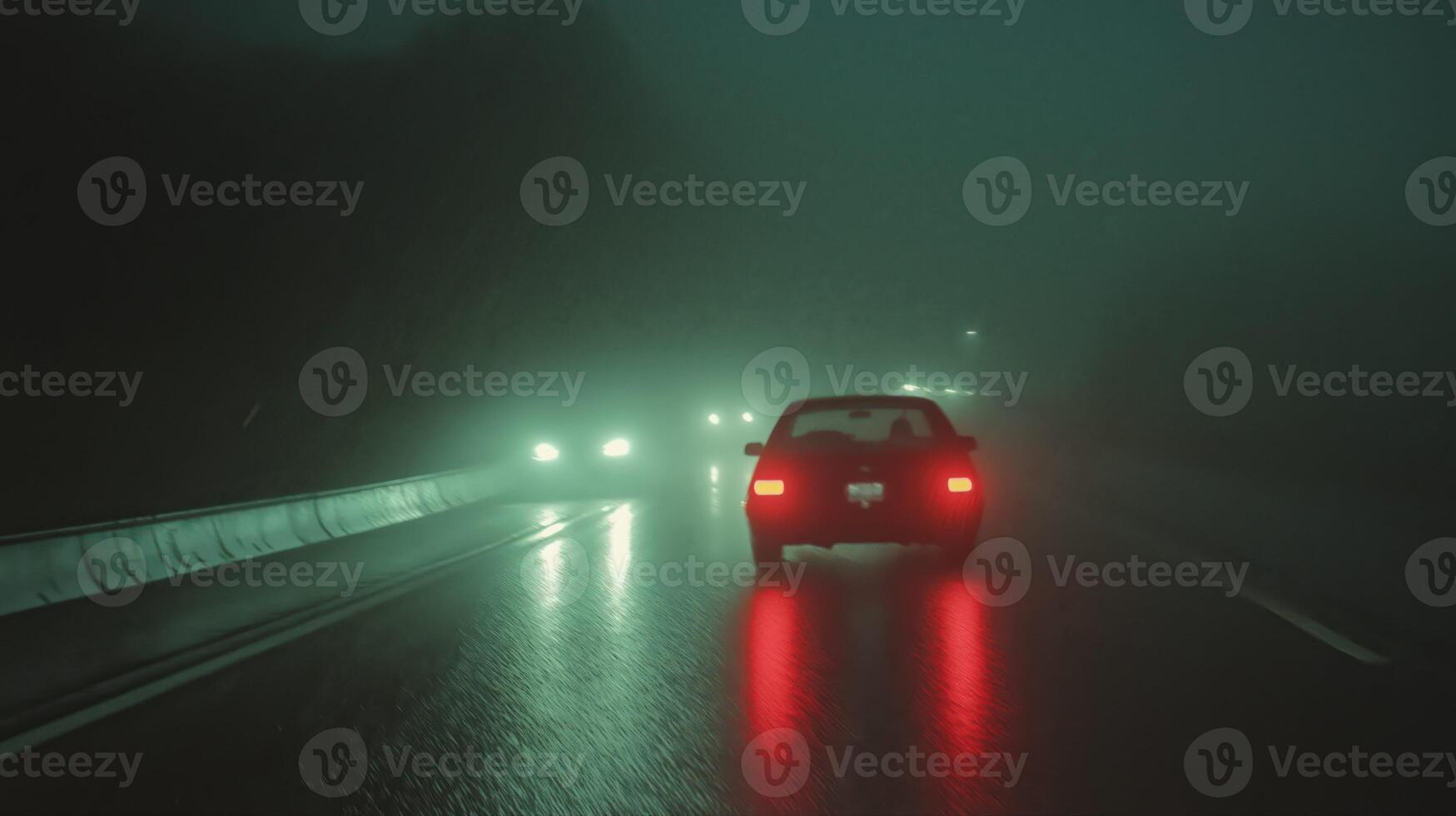 Night Driving in Dense Fog Rear View of Car on Wet Road photo