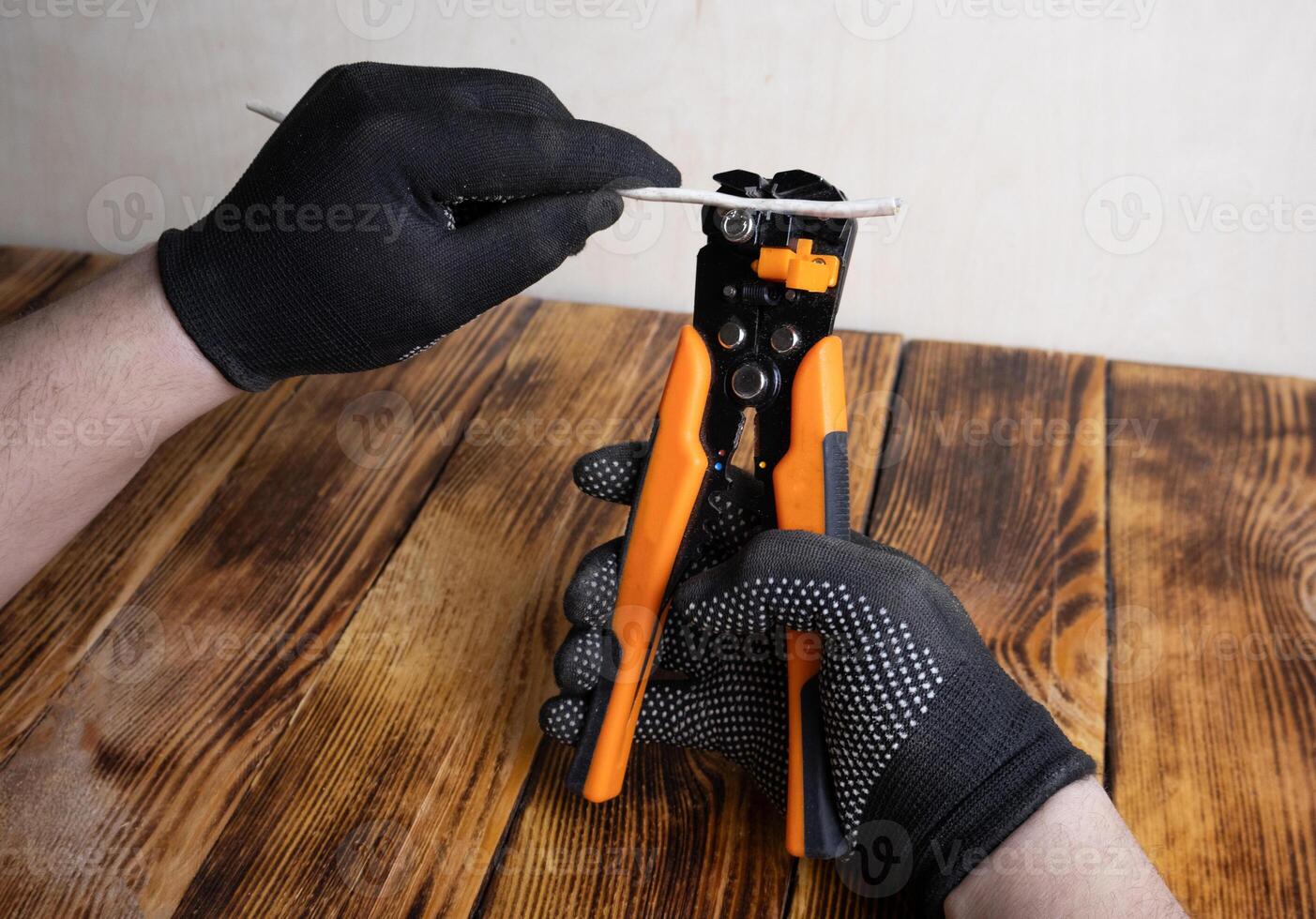 Man hands with glove using wire Stripping tool. photo