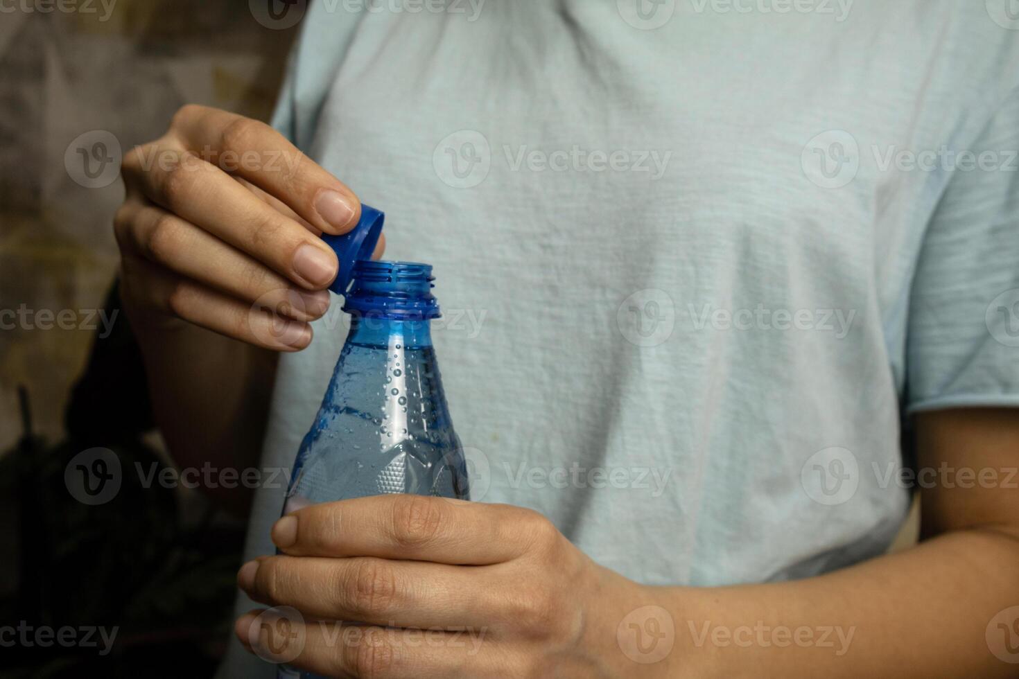 Bottle with stationary plastic cap in woman hand. photo