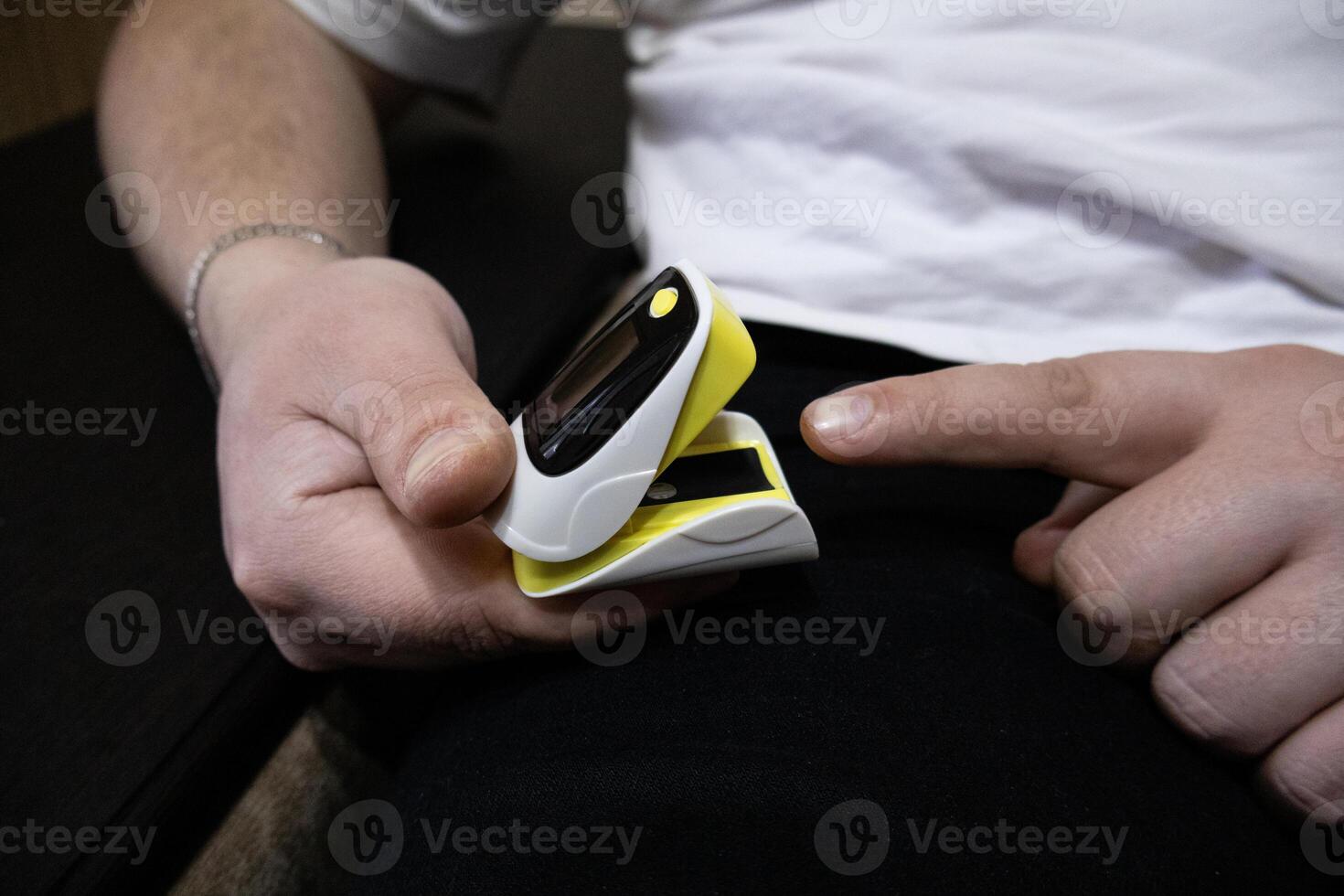 Close up of man hand using pulse oximeter photo