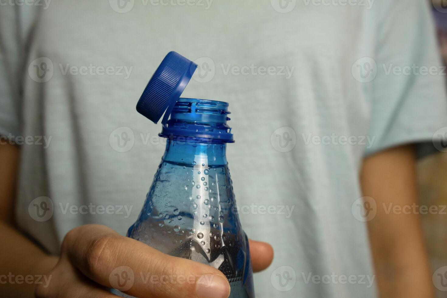 Bottle with stationary plastic cap in woman hands photo