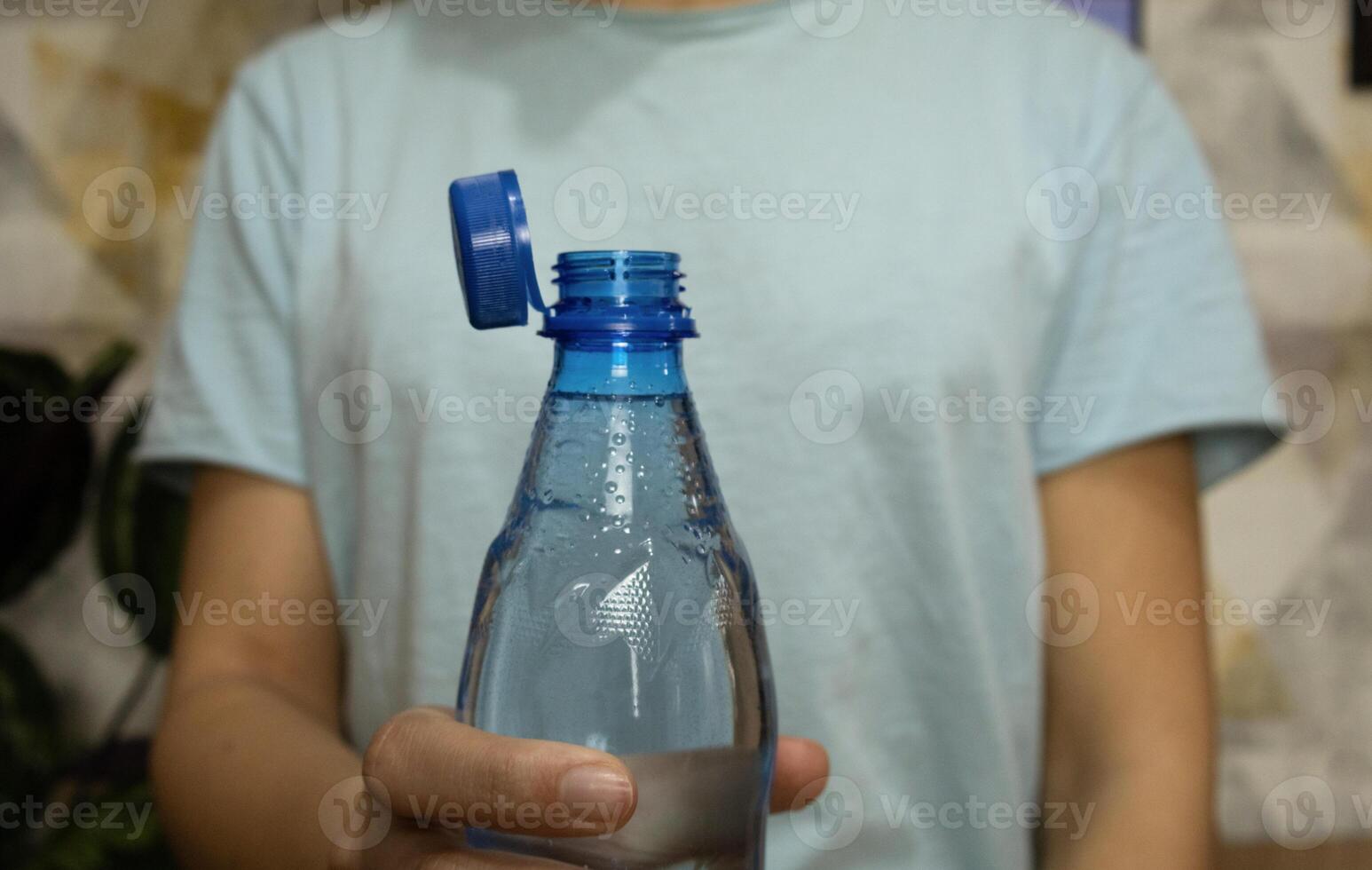 Bottle with stationary plastic cap in woman hand photo