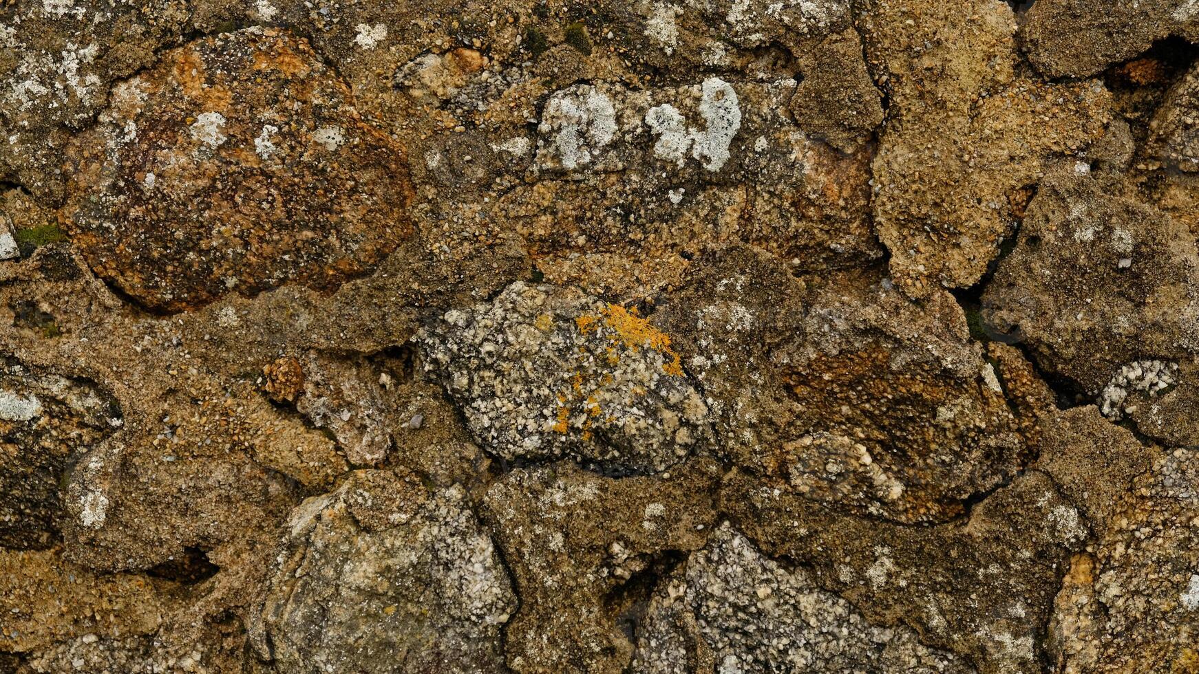 Texture of beige stone wall with rough masonry and uneven surface. Smooth, cracked surface. Old castle wall of stone different shape. Pattern with neutral colors. Minimal, stylish, trend concept photo