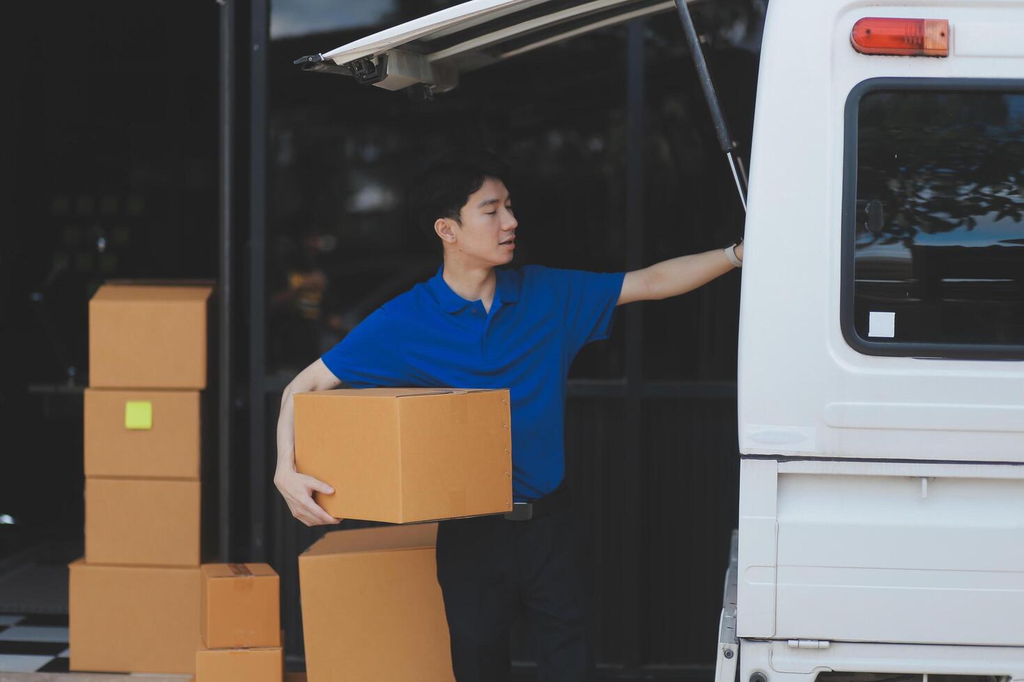 A man is standing next to a van with boxes photo