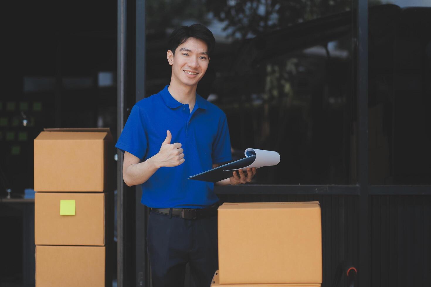 A man in a blue shirt holding a clipboard and giving the thumbs up photo