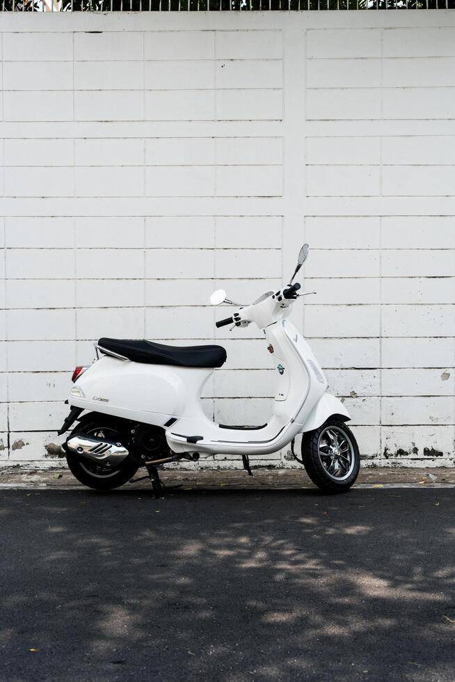 Bangkok, Thailand - March 17, 2025 Side view new white Vespa LX 125 scooter parked photo