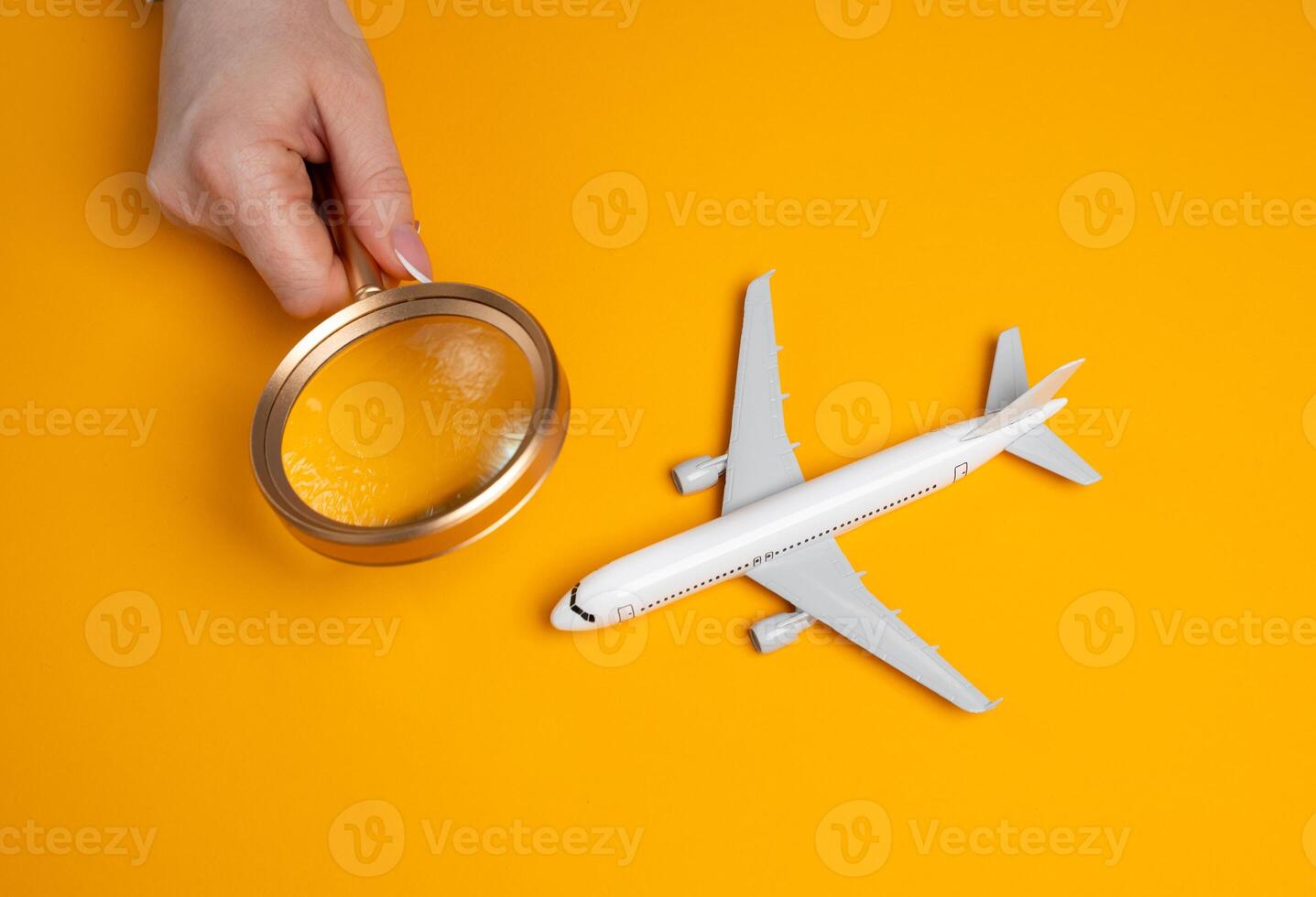 A woman examines a passenger plane with a magnifying glass. Quality and technical inspections of airline flight crews. Maintenance checks. Airline quality assurance photo