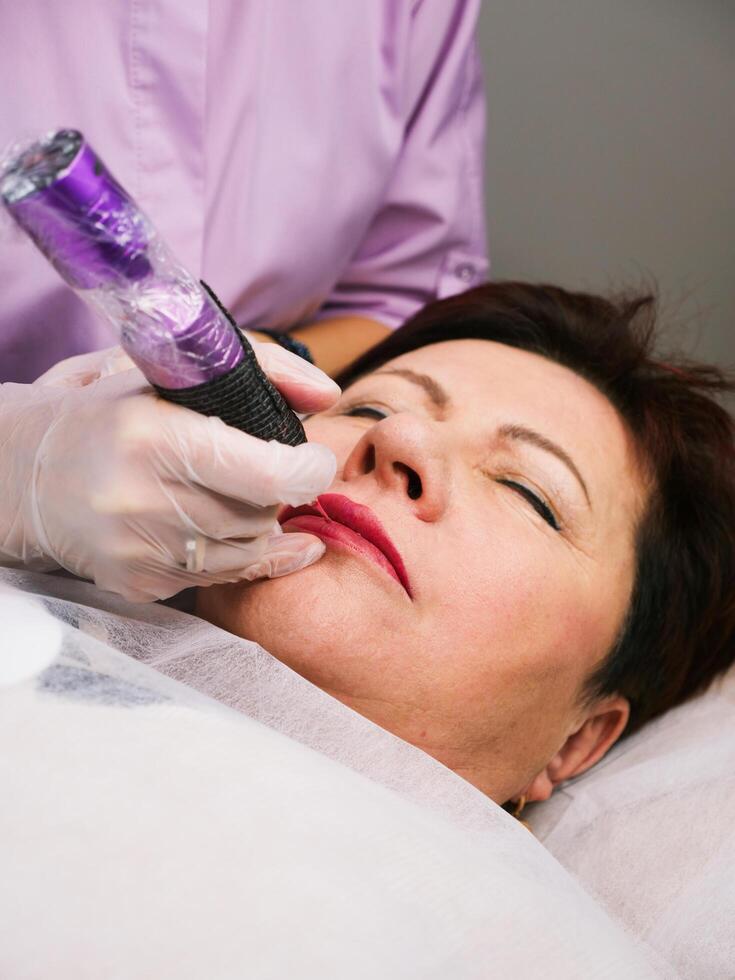 Permanent makeup lips of older senior woman photo