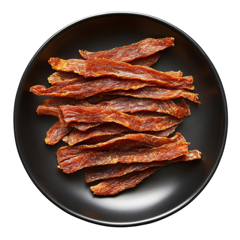 Dried meat strips arranged on a black plate for a savory snack experience, dried meat strips on black plate top view isolated on transparent background png