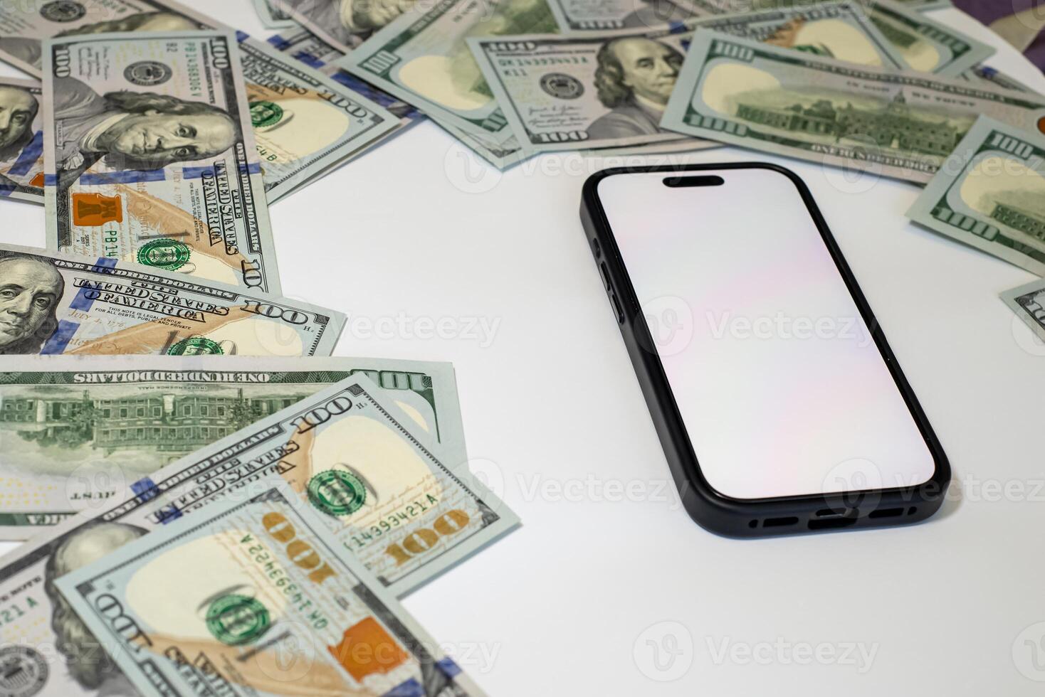 Currency arranged around a smartphone on a white surface in a composition on the theme of money, business, marketing, bank photo