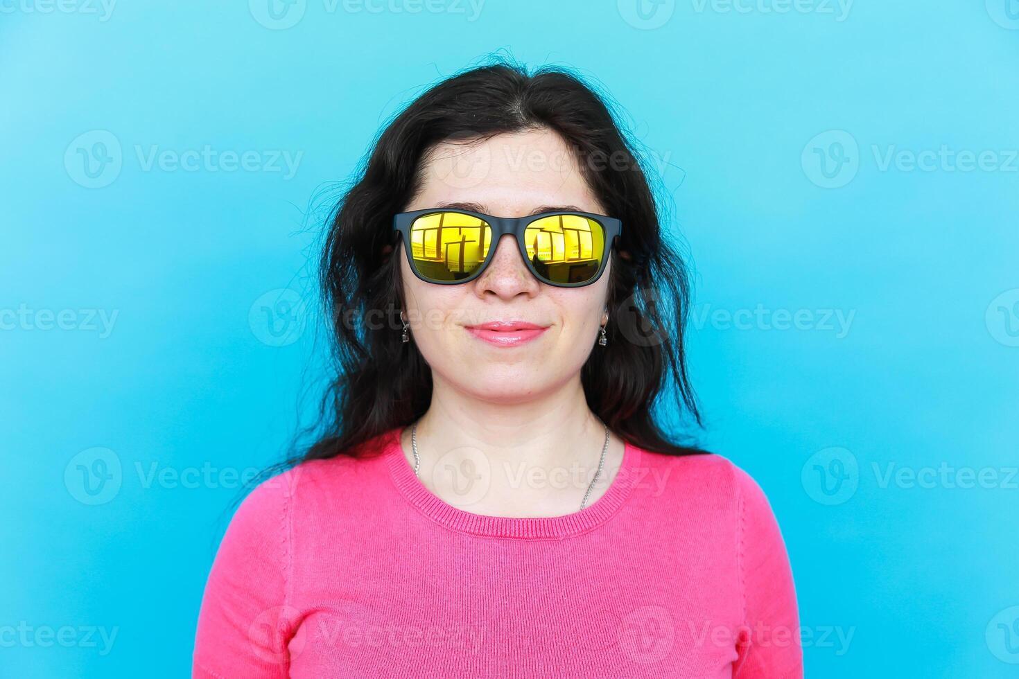 Fashion happy pretty smiling woman wearing a sunglasses over colorful blue background photo