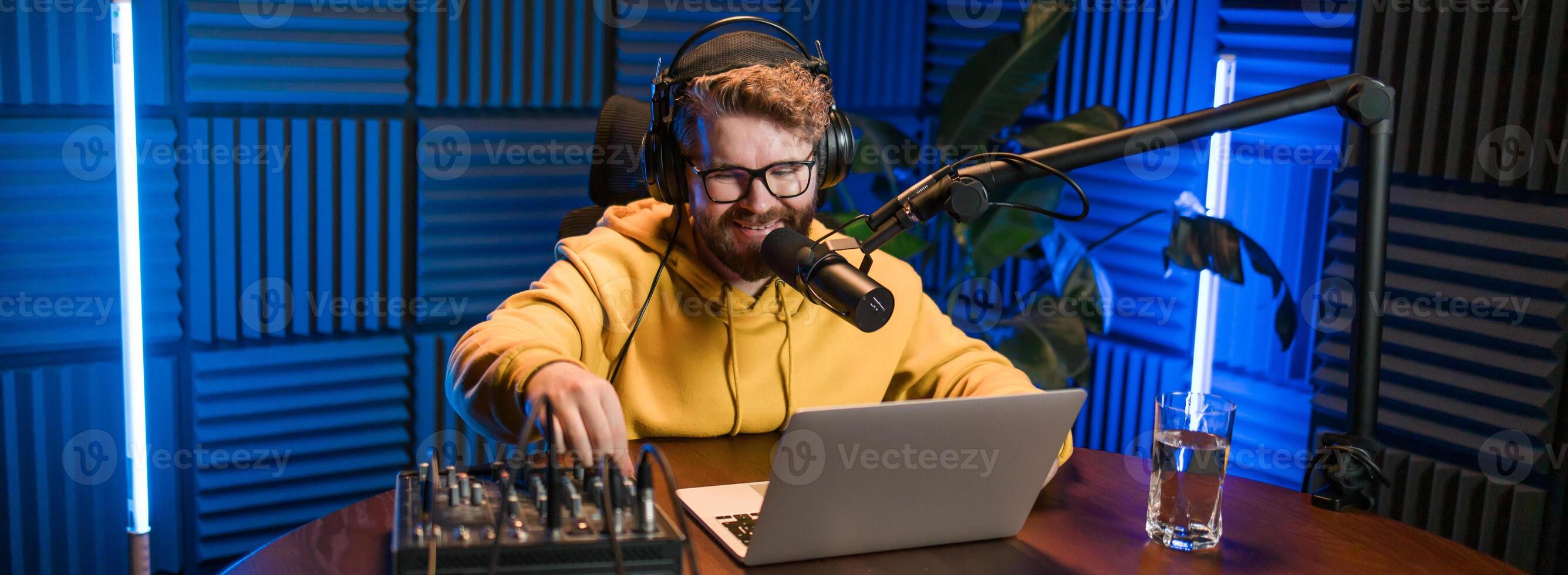 Banner Young smiling male radio presenter talking into the microphone and reading news, information and communication concept. Podcast and internet streaming concept. photo