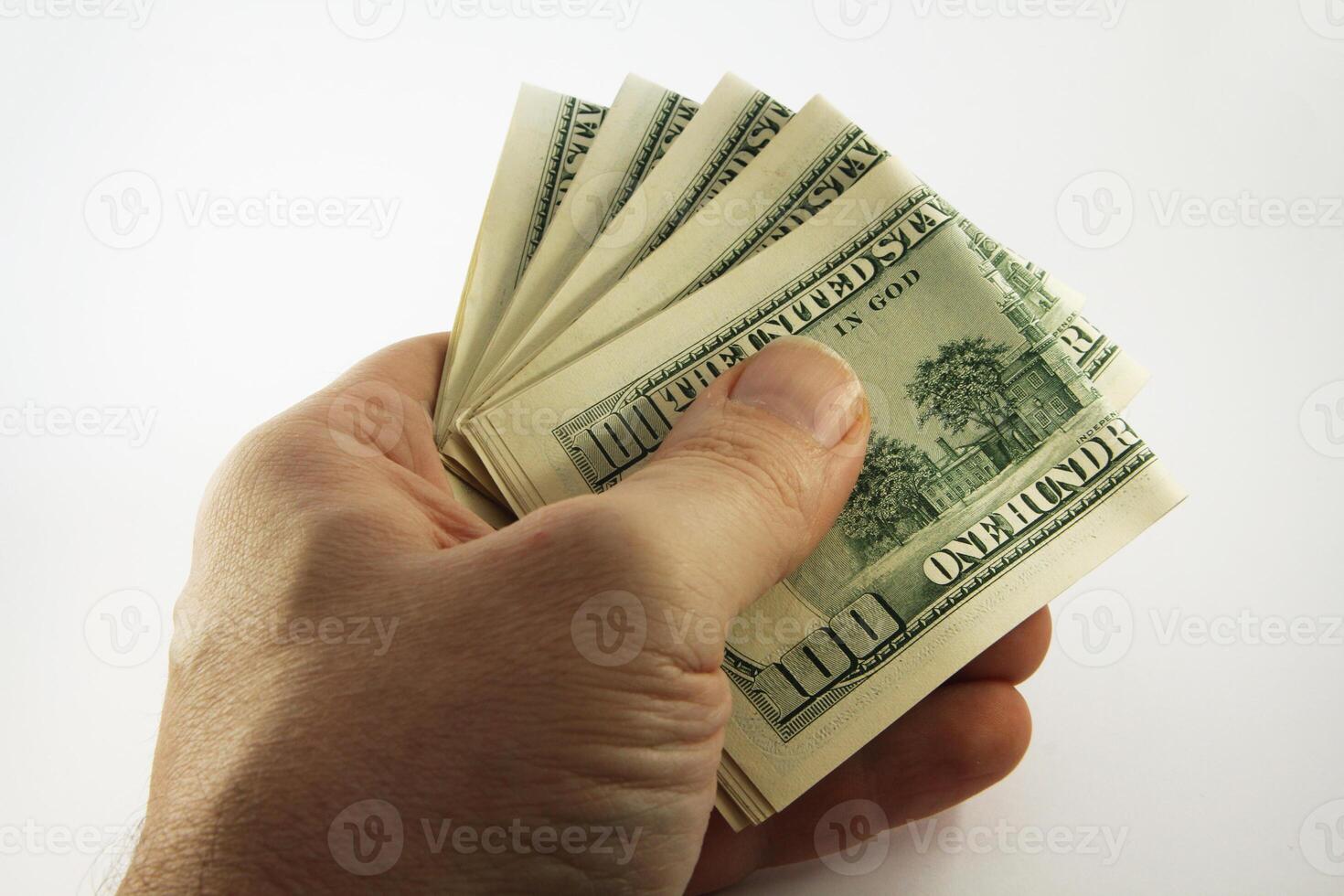 Hand Holding Bundles of American Hundred Dollar Bills on White Background photo