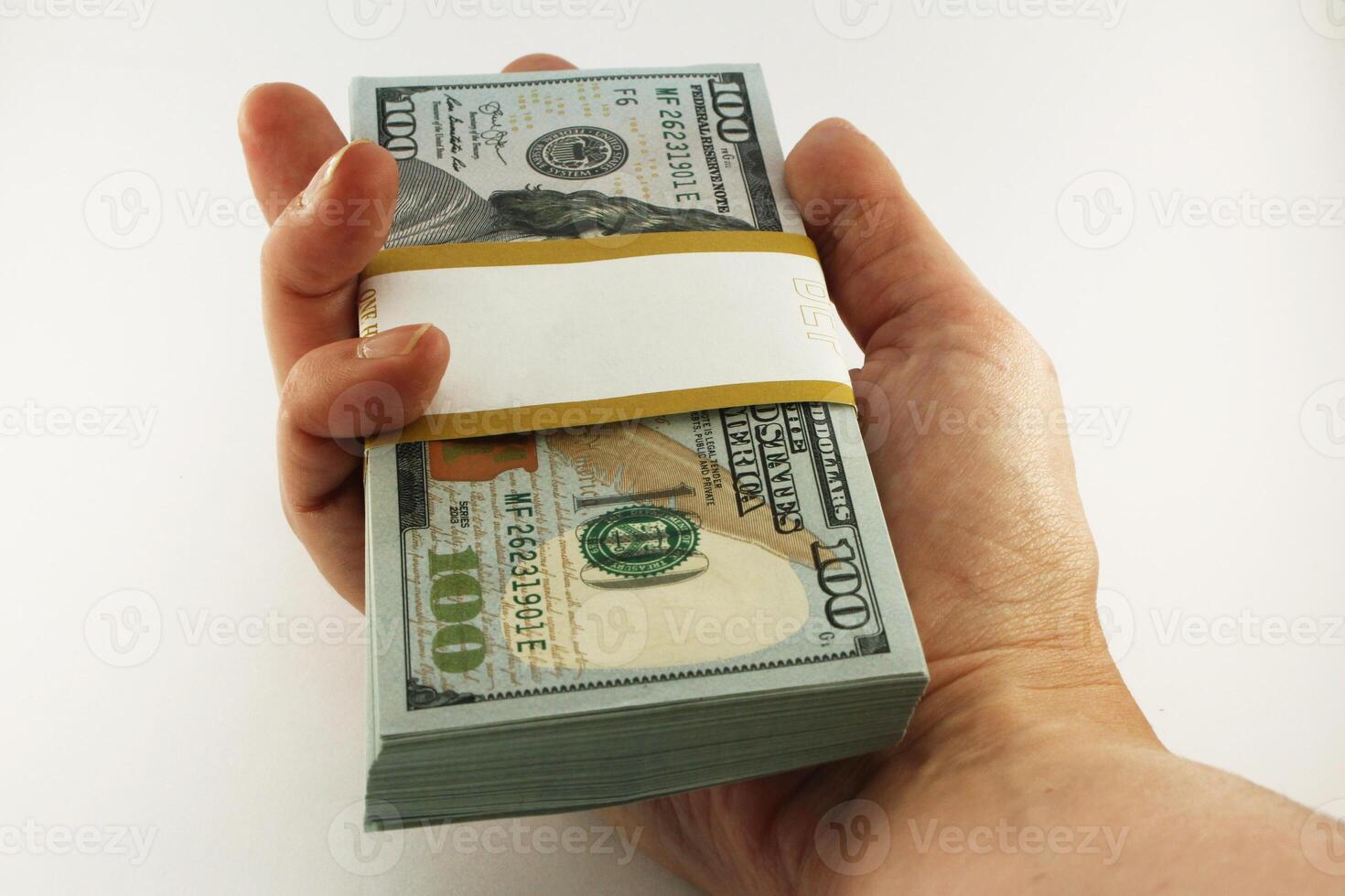 Hand Holding a Single Bundle of American Hundred Dollar Bills on White Background photo