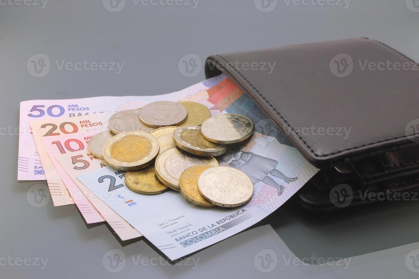 Colombian Currency, Pesos Bills and Coins Inside a Wallet on Dark Background photo