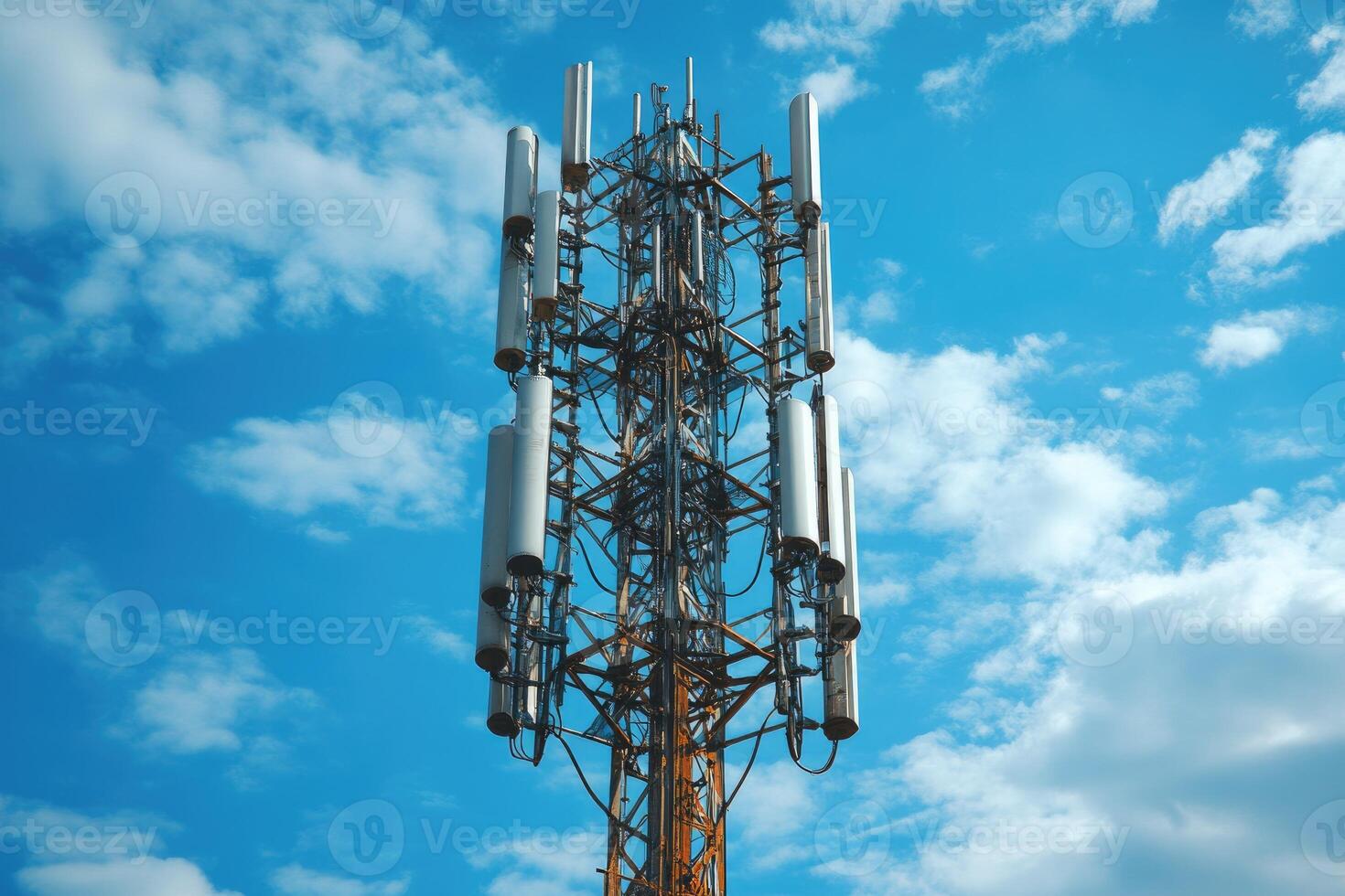 A Tall Cell Tower with Multiple Antennas Against a Blue Sky with White Clouds photo