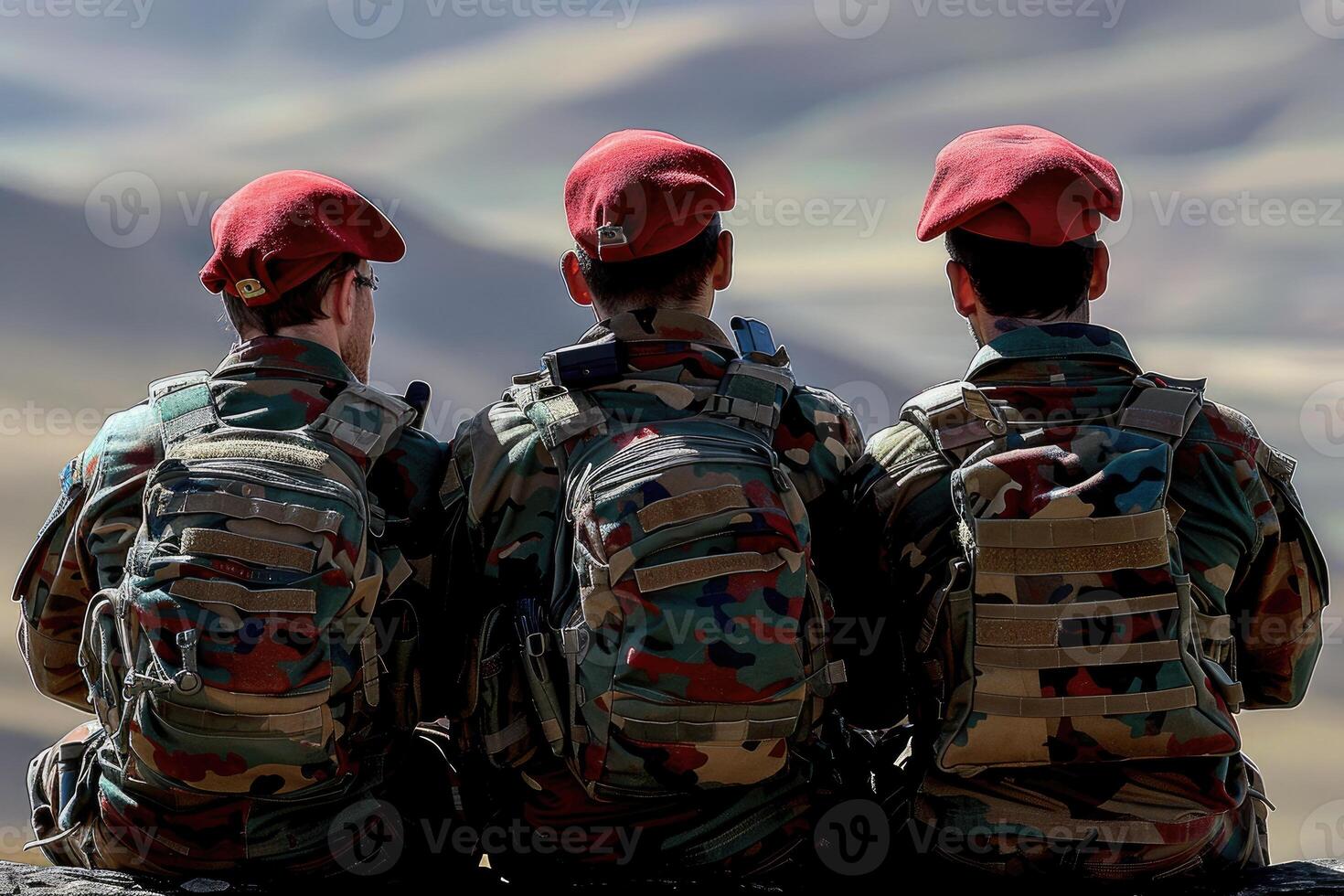 Three Soldiers in Red Berets and Camouflage Uniforms Sitting on a Rock photo