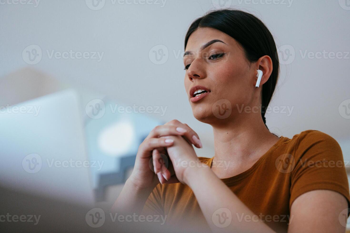 Woman sitting in living room using laptop looking at cam talk by call with business friend relatives, head shot. Job interview answering questions photo