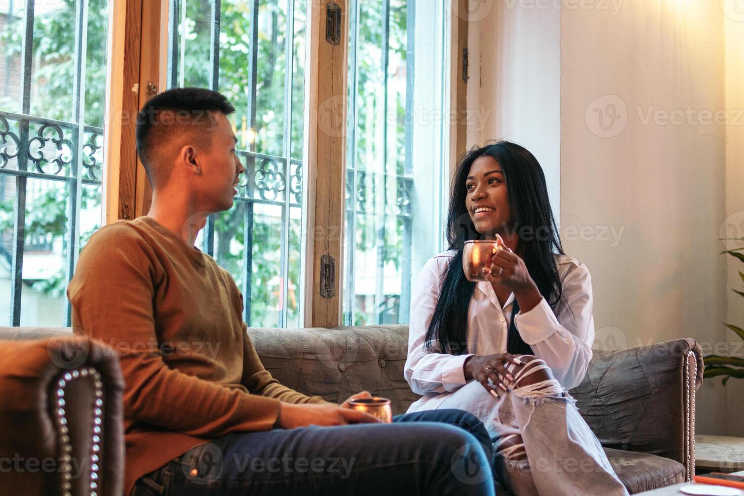 Asian man and Latina woman on a date. Couple talking to each other photo