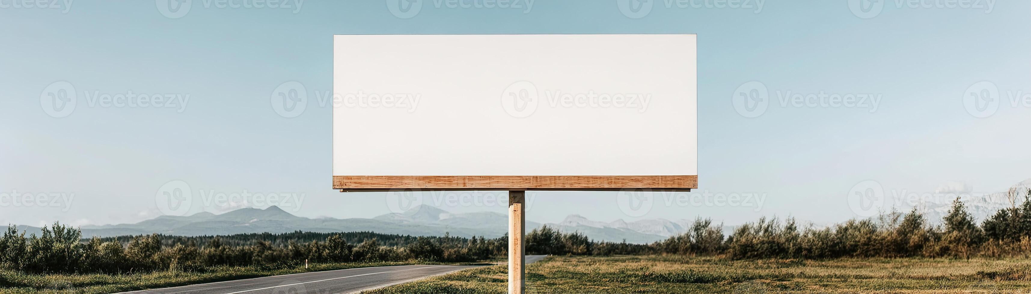 A large blank billboard stands alone on a tranquil country road. Lush green fields stretch out on either side, complementing the serene blue sky. Ideal for brands focused on nature and wellness photo