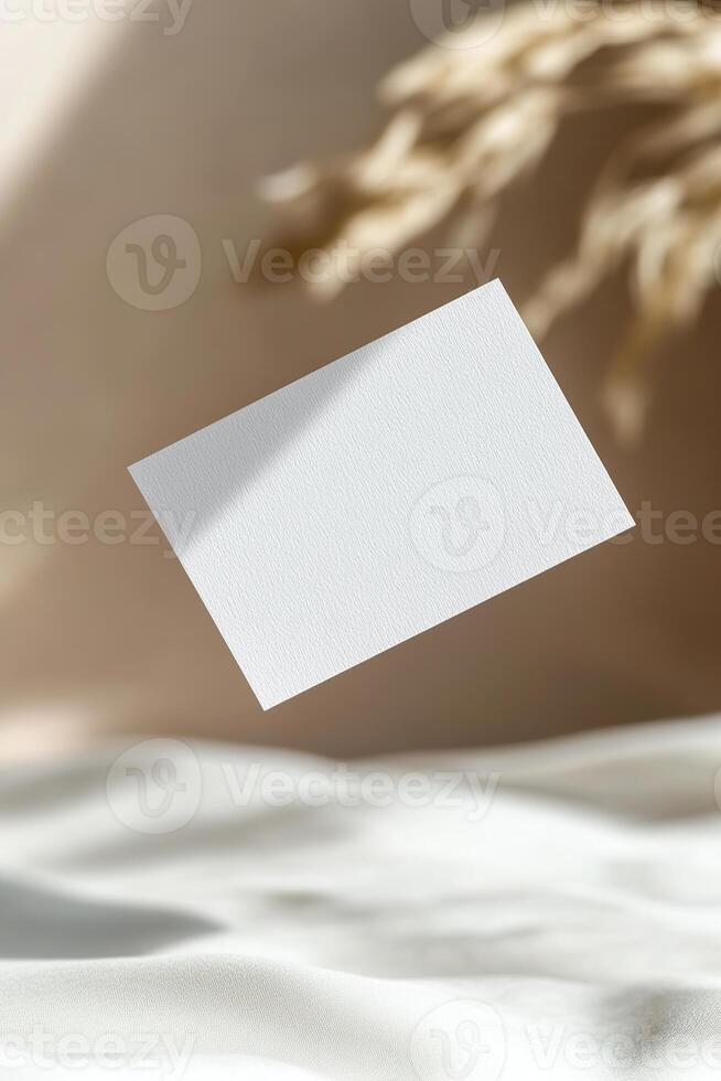 A blank business card appears to float in midair, casting a soft shadow. The background features a smooth gradient that enhances the sleek and modern aesthetic, ideal for branding presentations photo