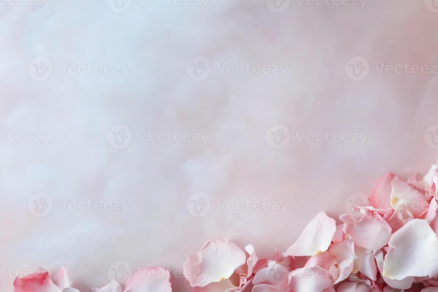 Rose petals in shades of pink and red are scattered gracefully along a smooth, pastel-toned surface. The softly blurred upper section allows space for elegant text, perfect for special events photo