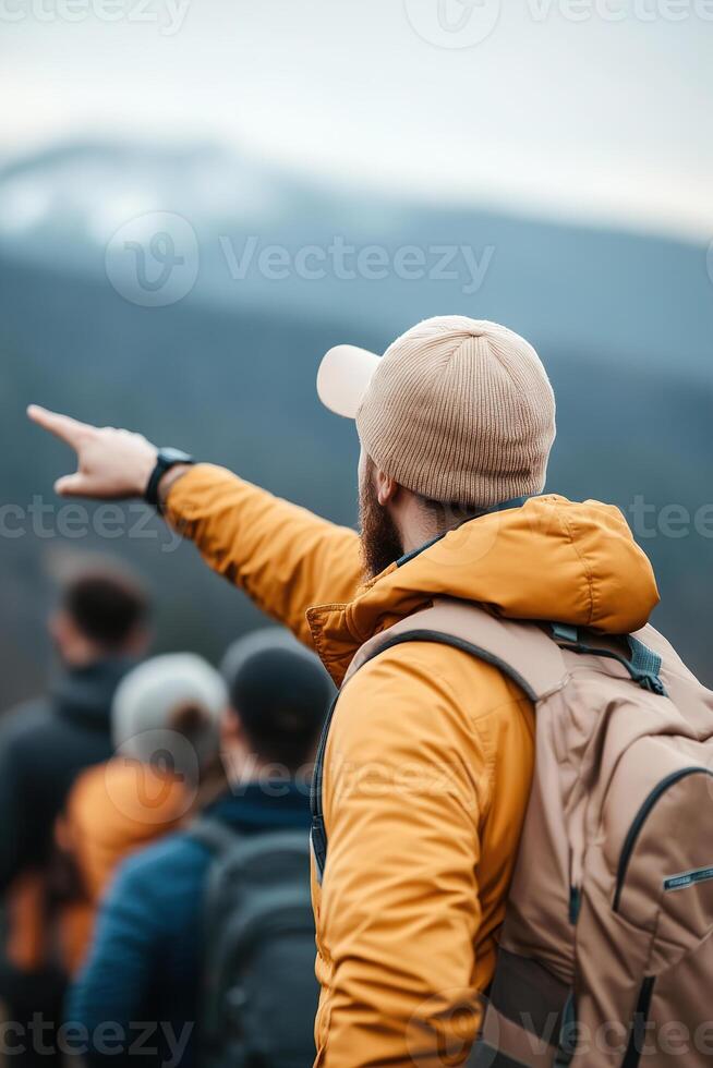 A travel guide dressed in casual outdoor attire enthusiastically points at a stunning mountain vista, engaging a group of curious tourists in an adventurous exploration filled with excitement photo