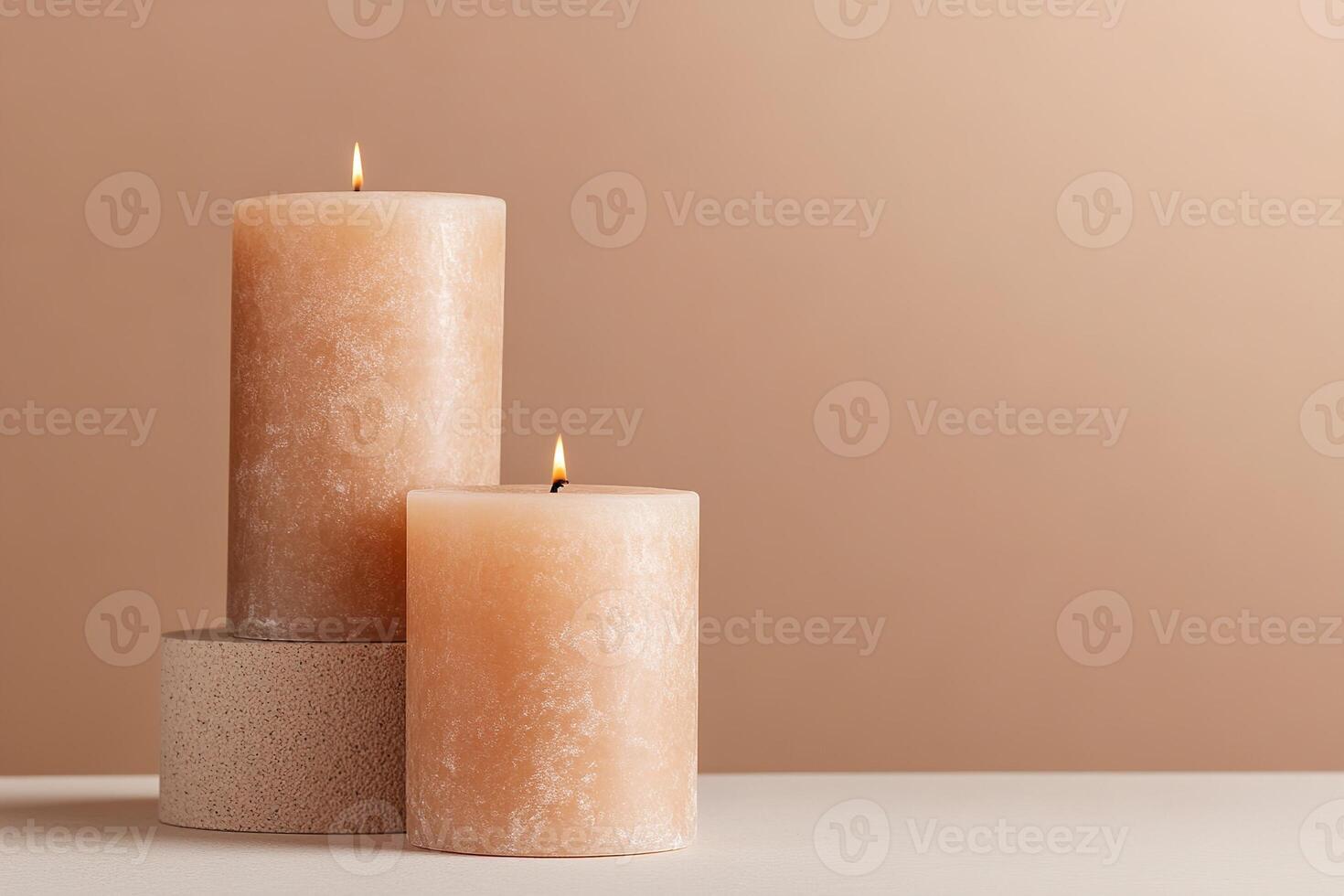 In a dimly lit room, a warm amber candle gently flickers, creating a soothing atmosphere. The softly blurred background features neutral beige and warm brown tones, perfect for relaxation photo