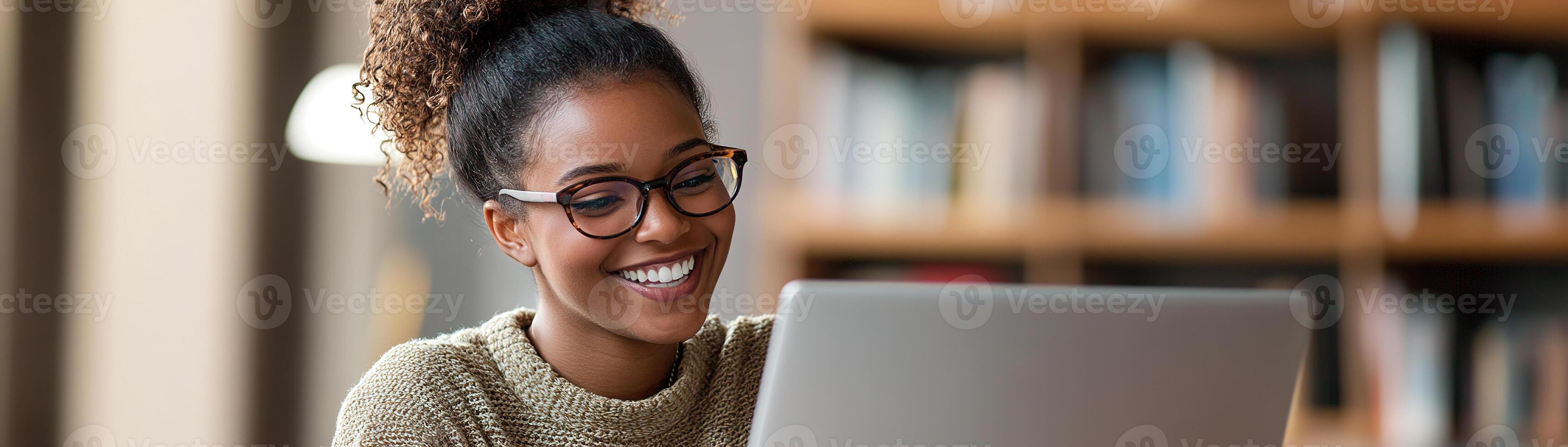 A tutor sits at a desk with an open laptop, smiling as she guides a student through an online lesson. Educational materials and books subtly enhance the learning atmosphere photo