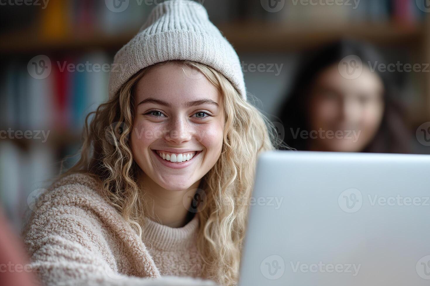 A cheerful tutor assists a student with their online lesson, seated at a desk with a laptop. Educational materials are visible in the soft background, enhancing the focus on learning photo